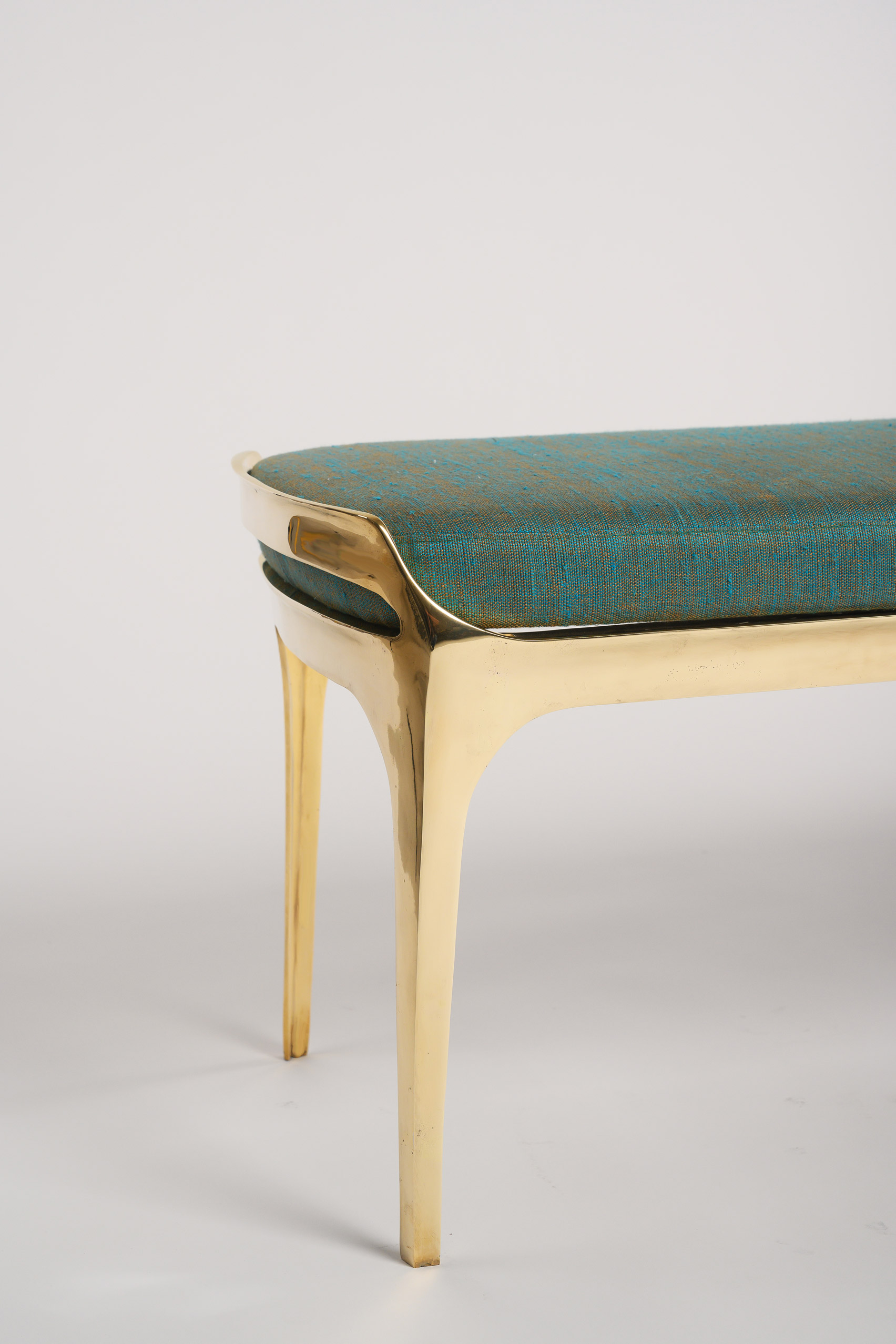 End of Bruda bench by Elan Atelier showing its gleaming gold finish