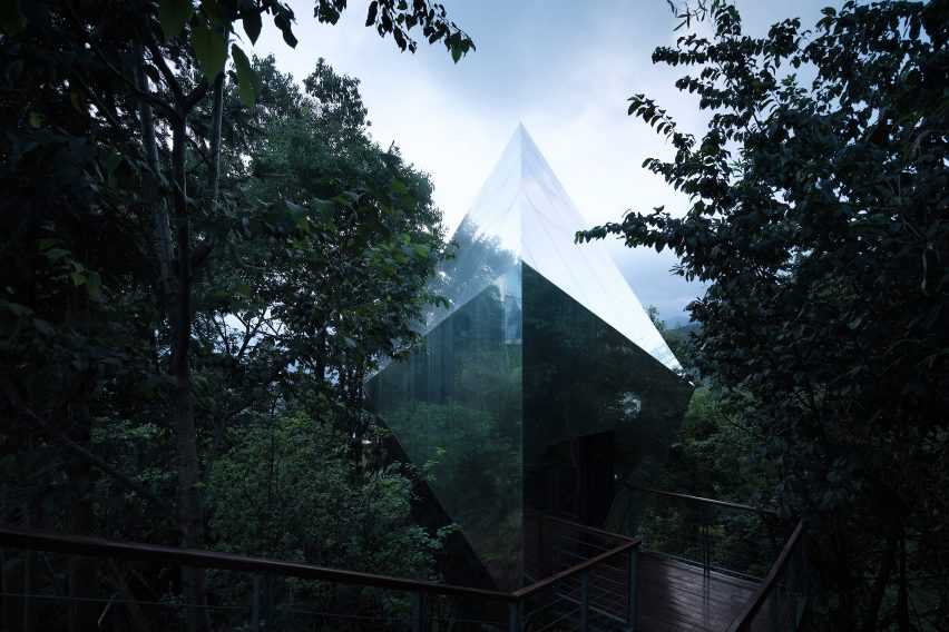 Mirrored cabins sit within the tree-line