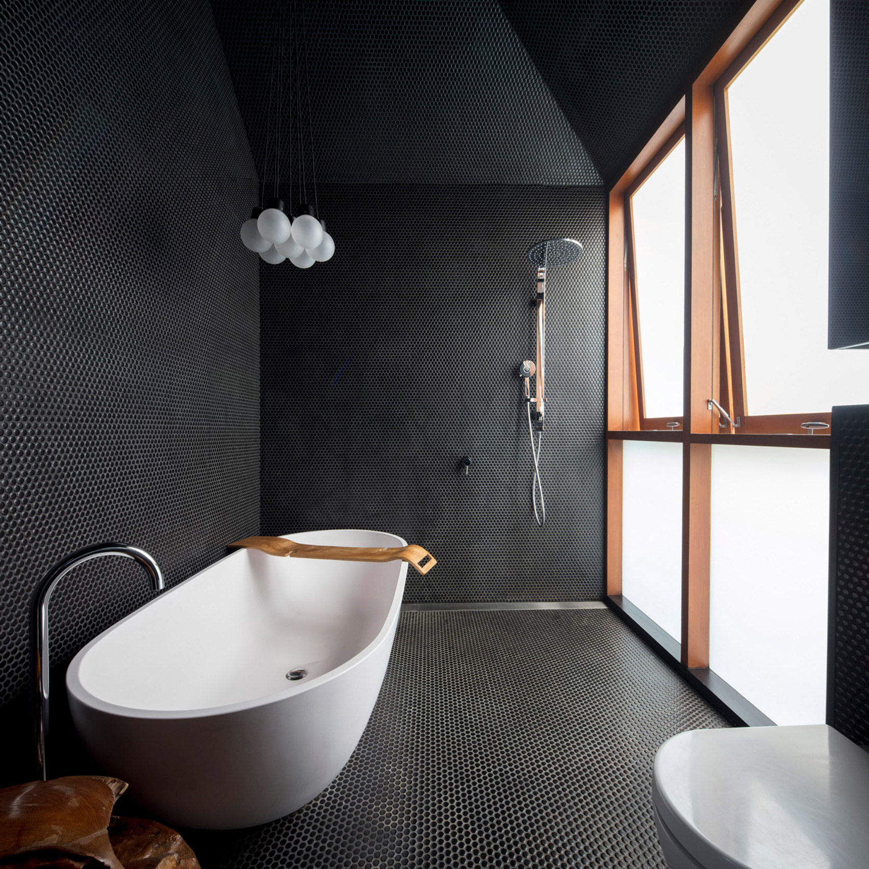 Black-tiled bathroom with freestanding bath