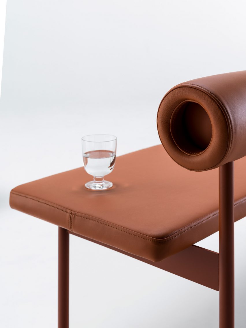 Font sofa in terracotta leather with a glass of water balanced on it
