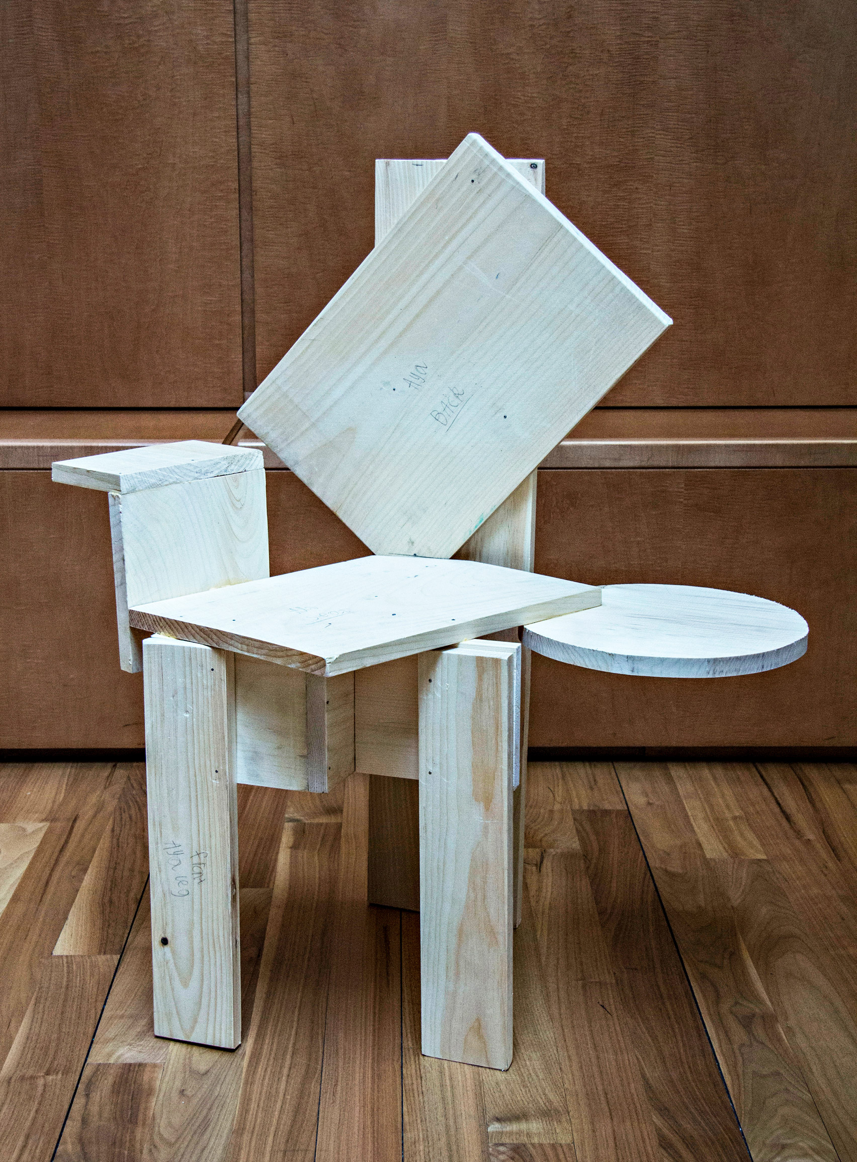 Unpainted, asymmetrical chair from Grade Three Chairs project by Bruce Edelstein at Trinity School