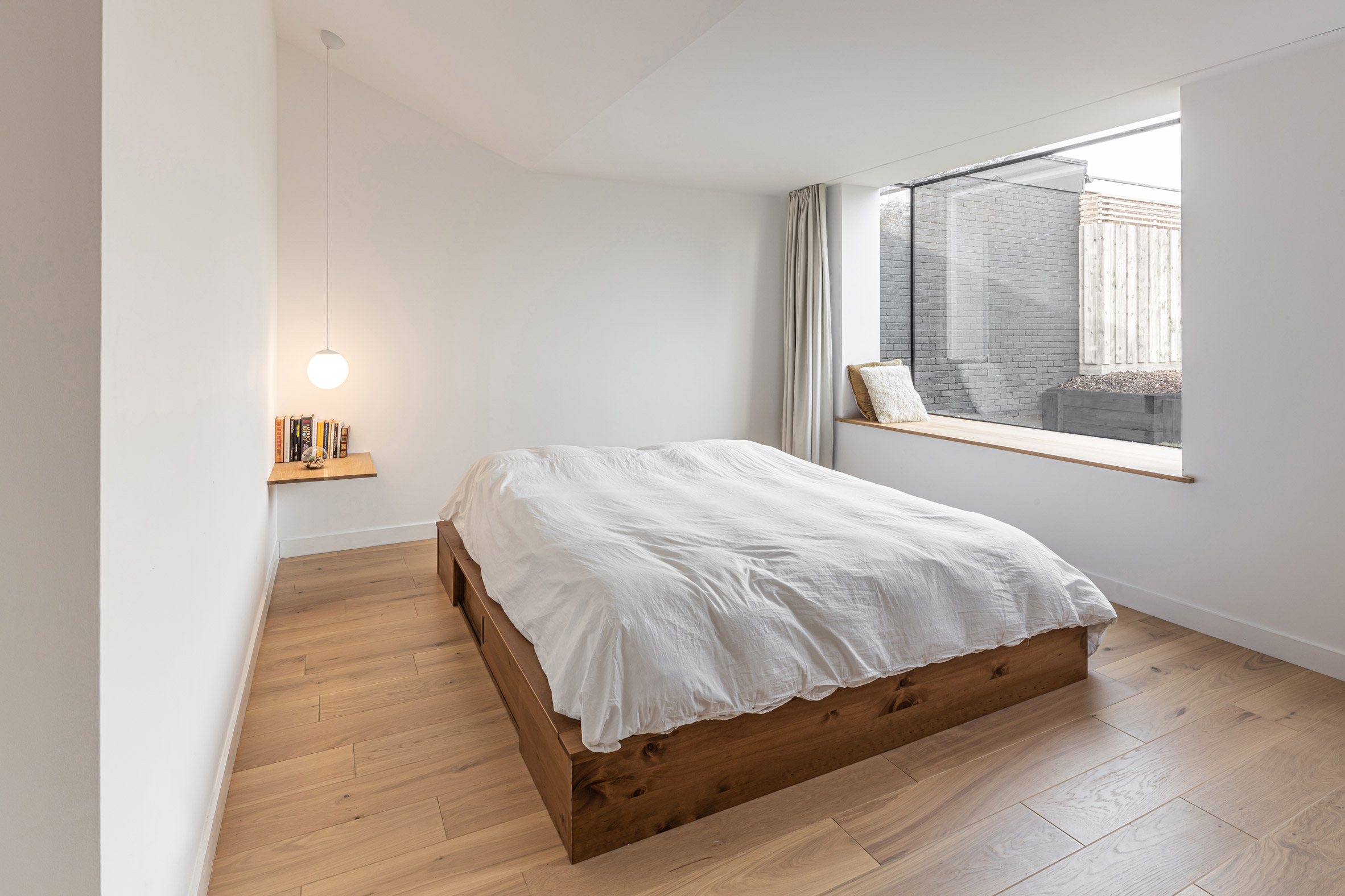 Master bedroom in Honey and Walnut House by Intervention Architecture