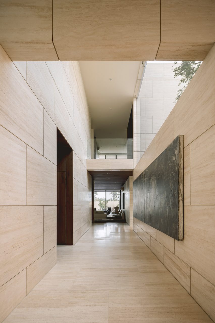 Travertine walls and art inside Casa ZTG by 1540 Arquitectura