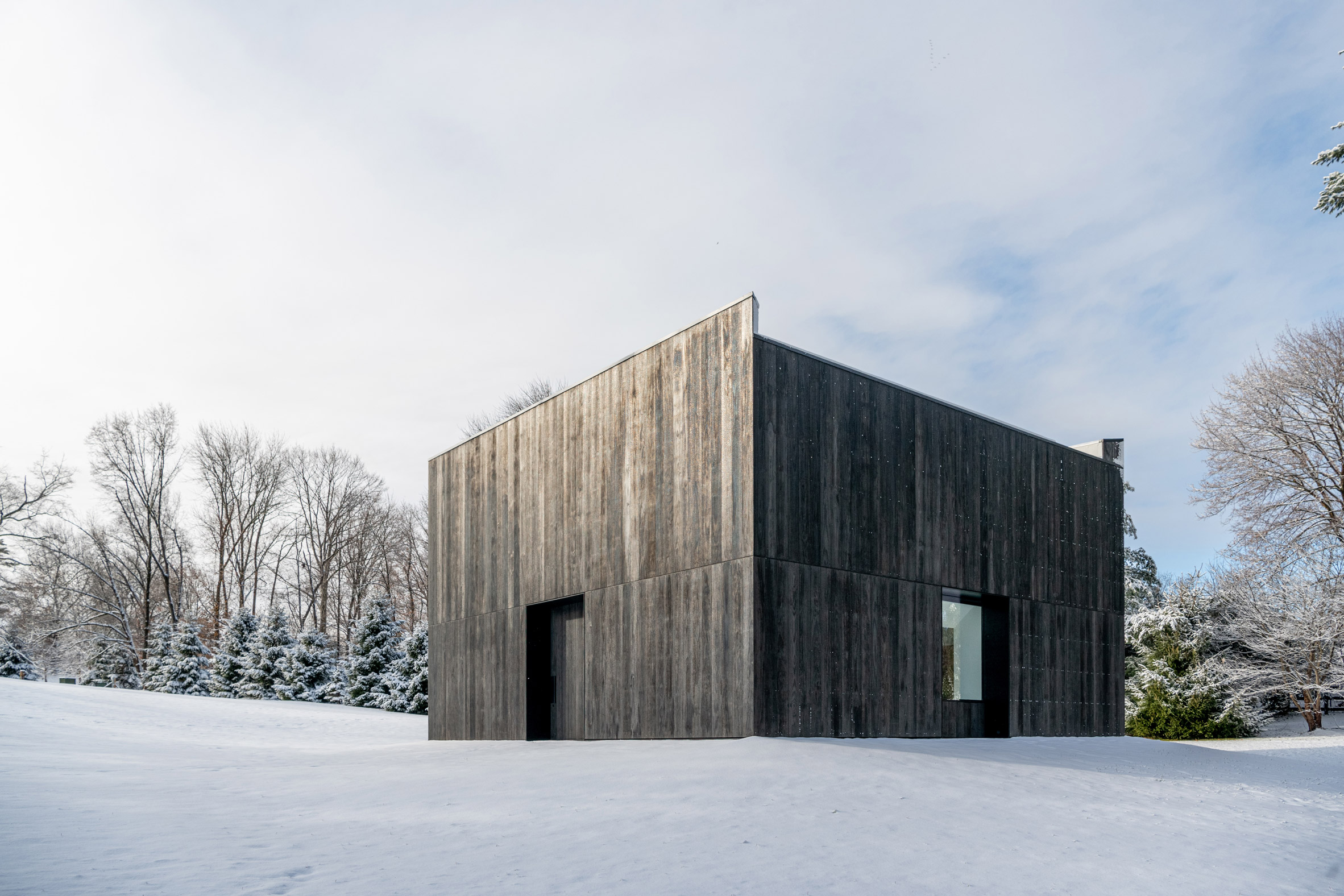 Snow surrounds charred-wood clad pavilion by OLI Architecture