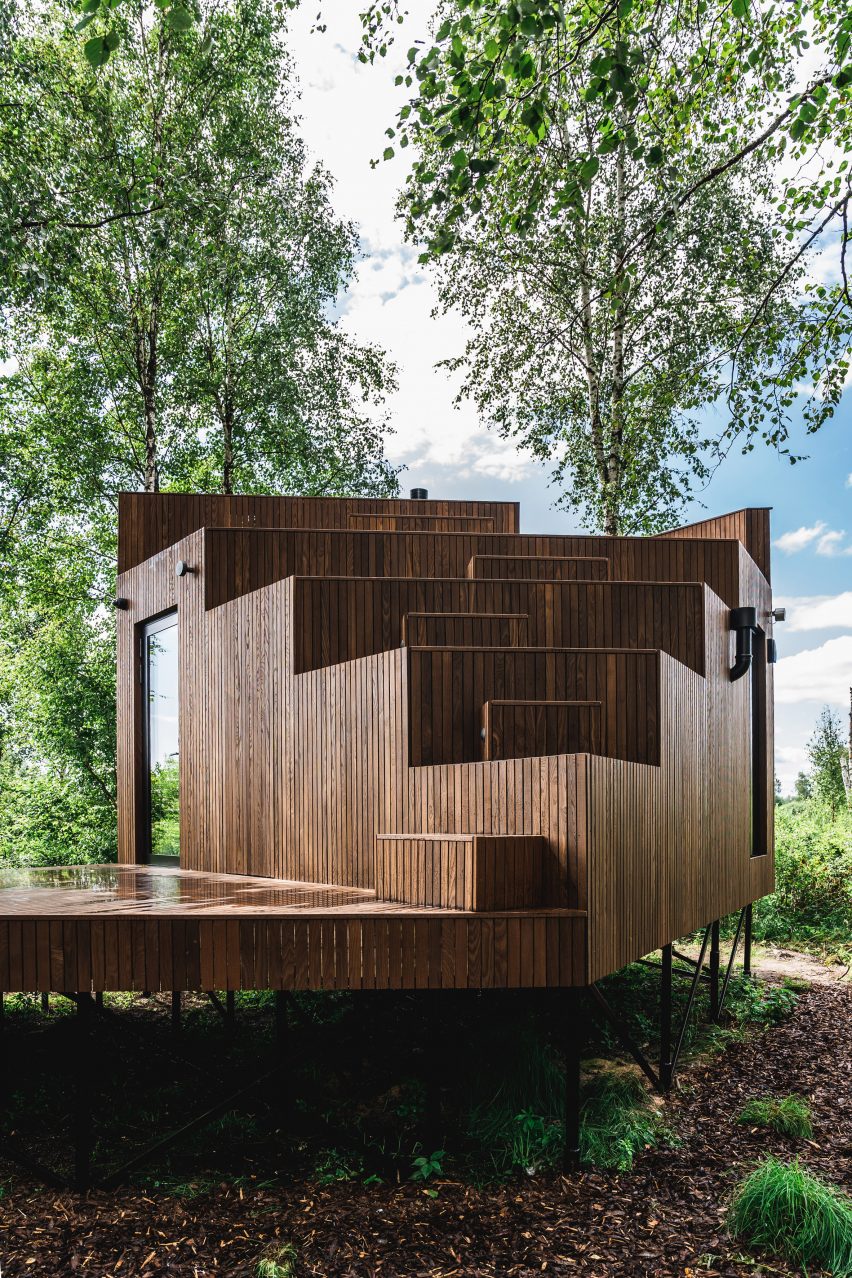 A stilted wooden cabin with a stepped facade