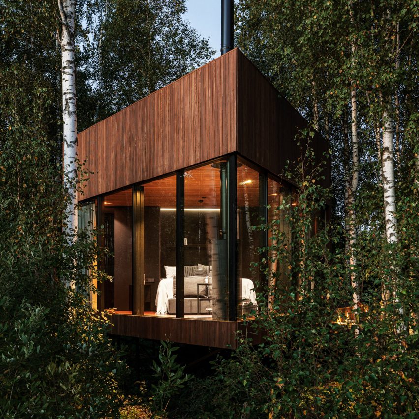 A glass and wood cabin in woodland