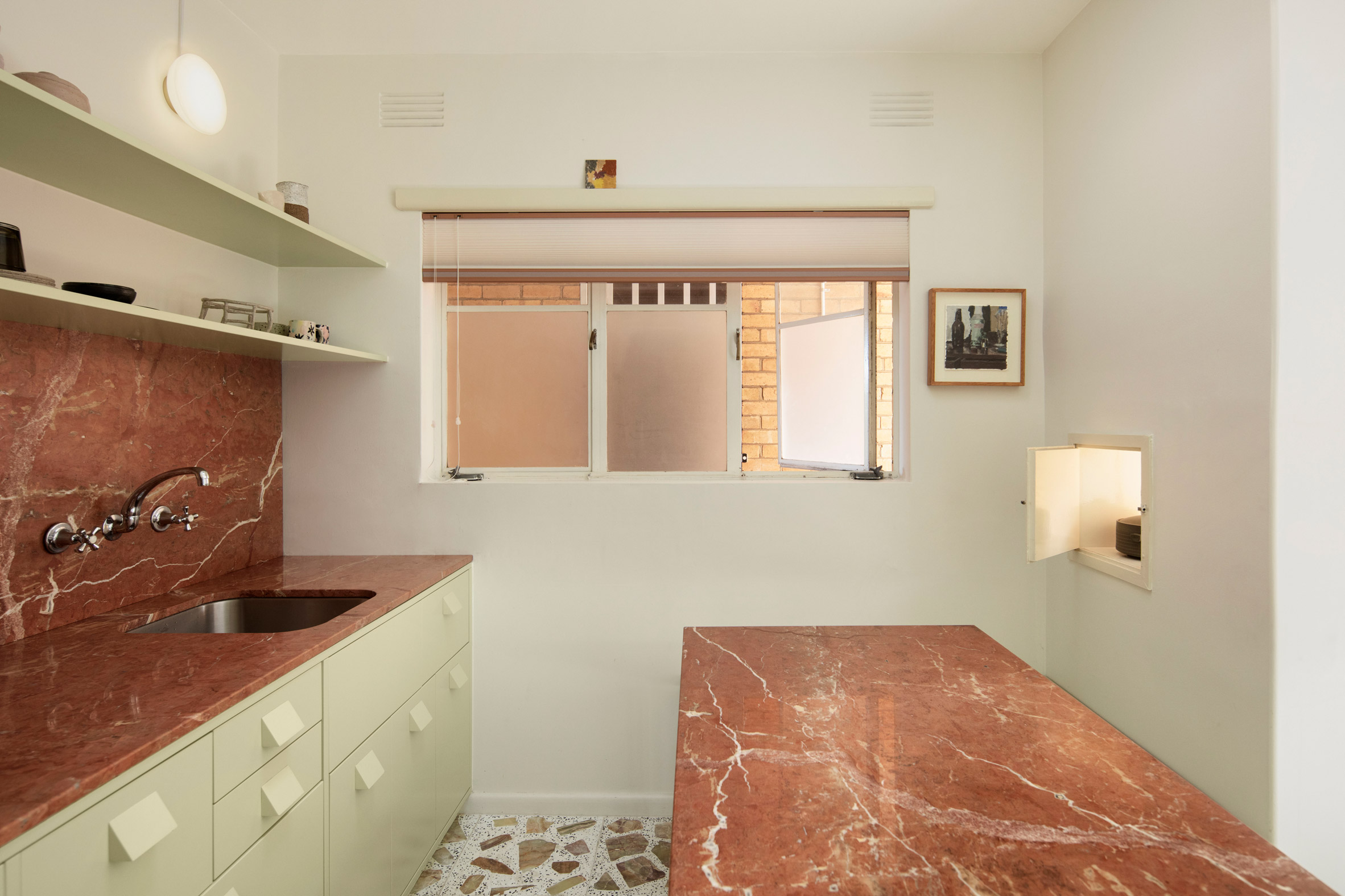 Red marble worktops and terrazzo tiles in mid-century renovation by Murray Barker and Esther Stewart