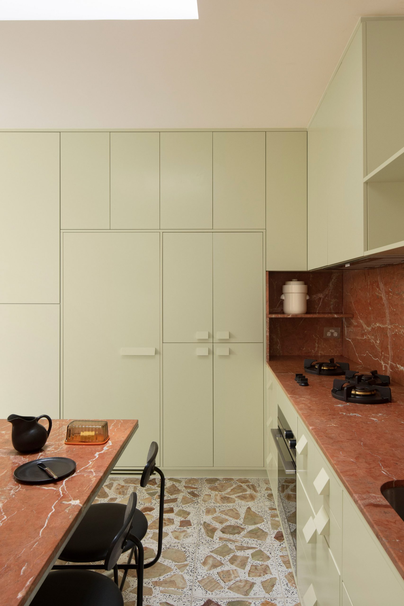 Pistachio green cabinets and red marble worktops in Brunswick apartment by Murray Barker and Esther Stewart