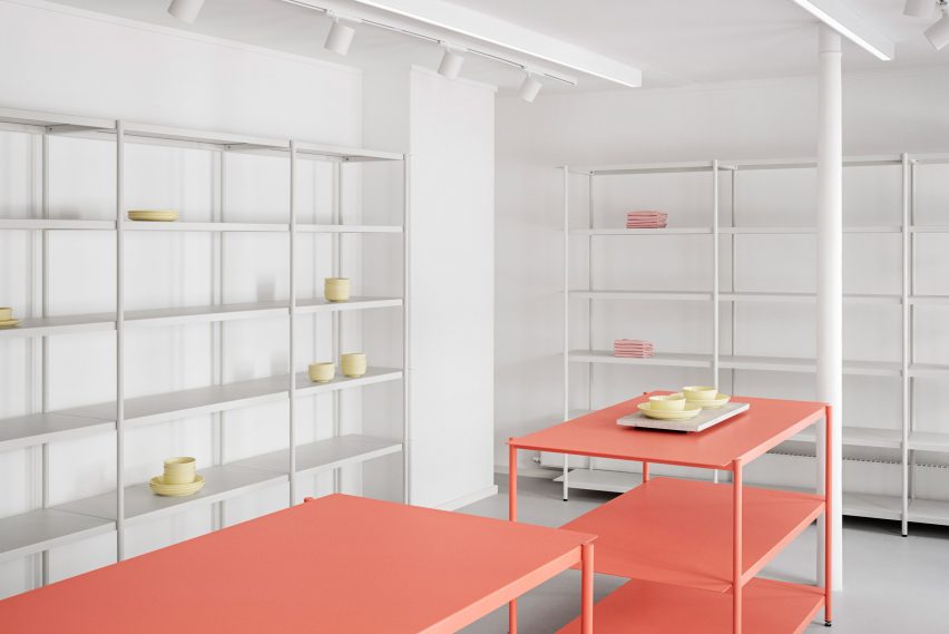 White and coral-coloured steel shelving in the OCE Copenhagen store interior