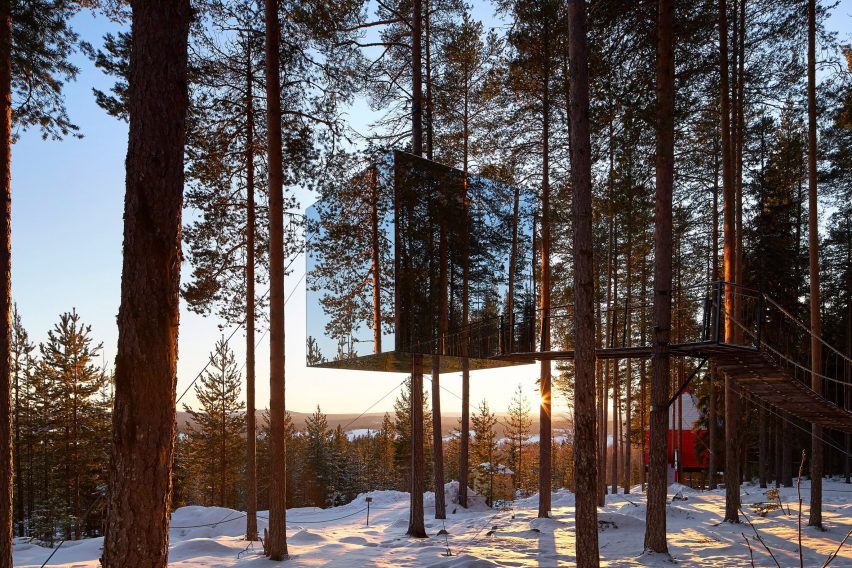 Mirrored cabin perched above ground blends with the sky and trees