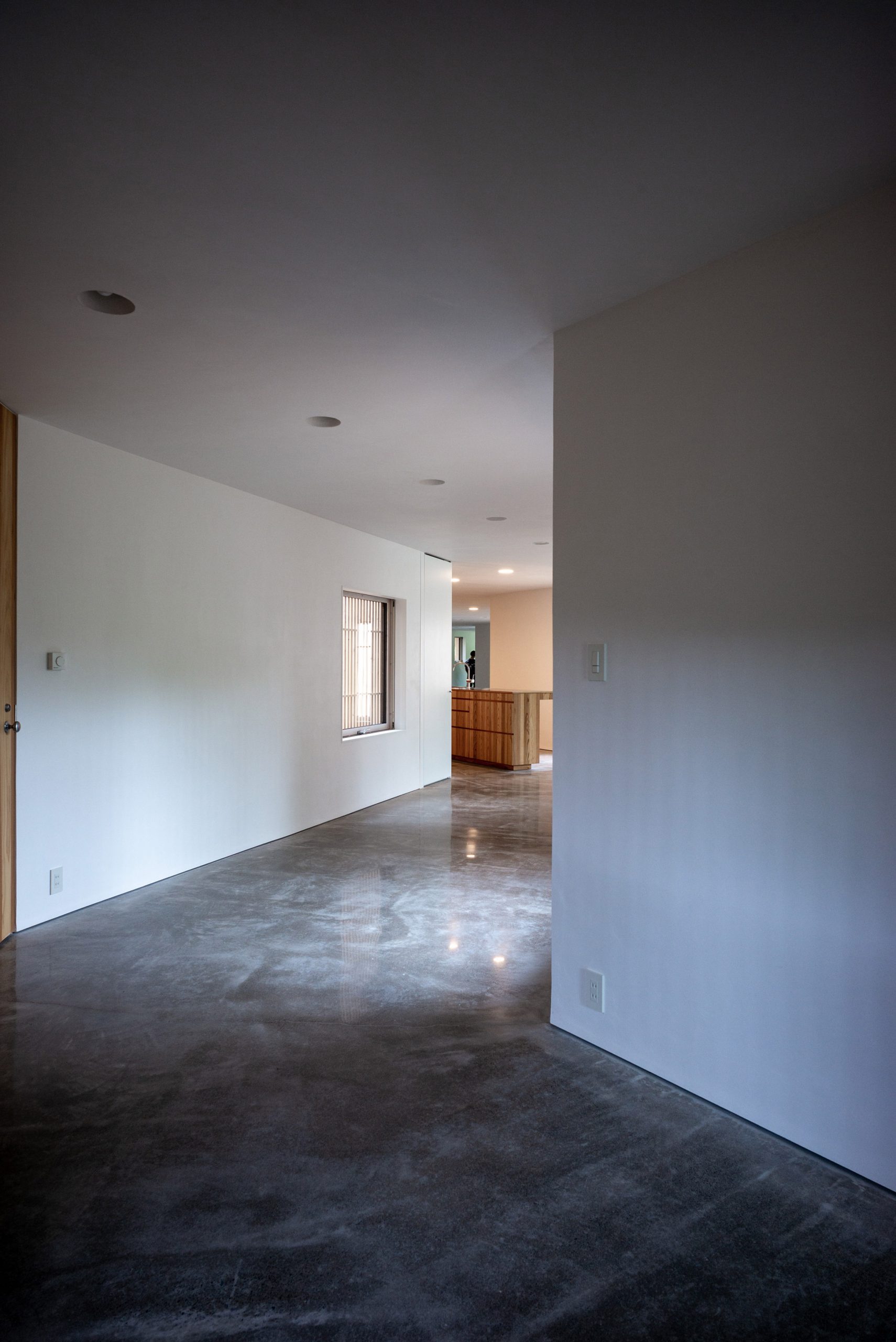 The interior has white walls and a polished concrete floor