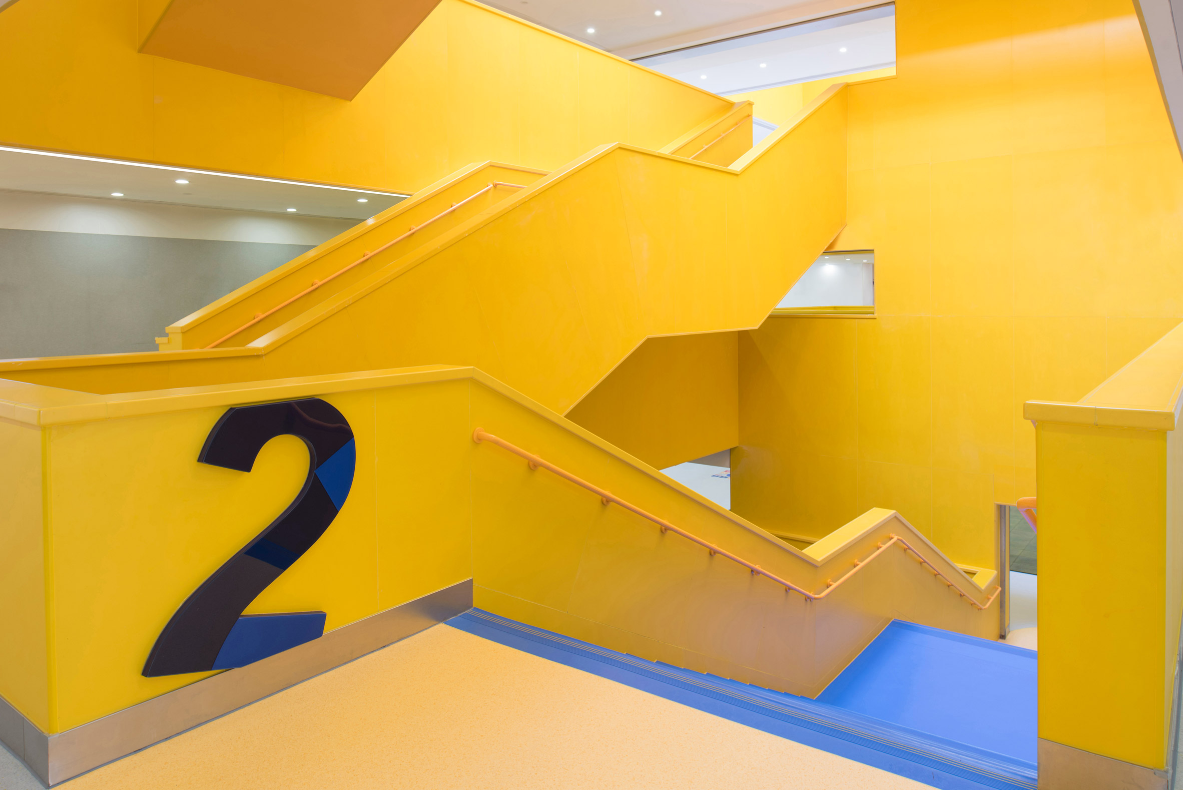 Yellow staircase is decorated with large numbers