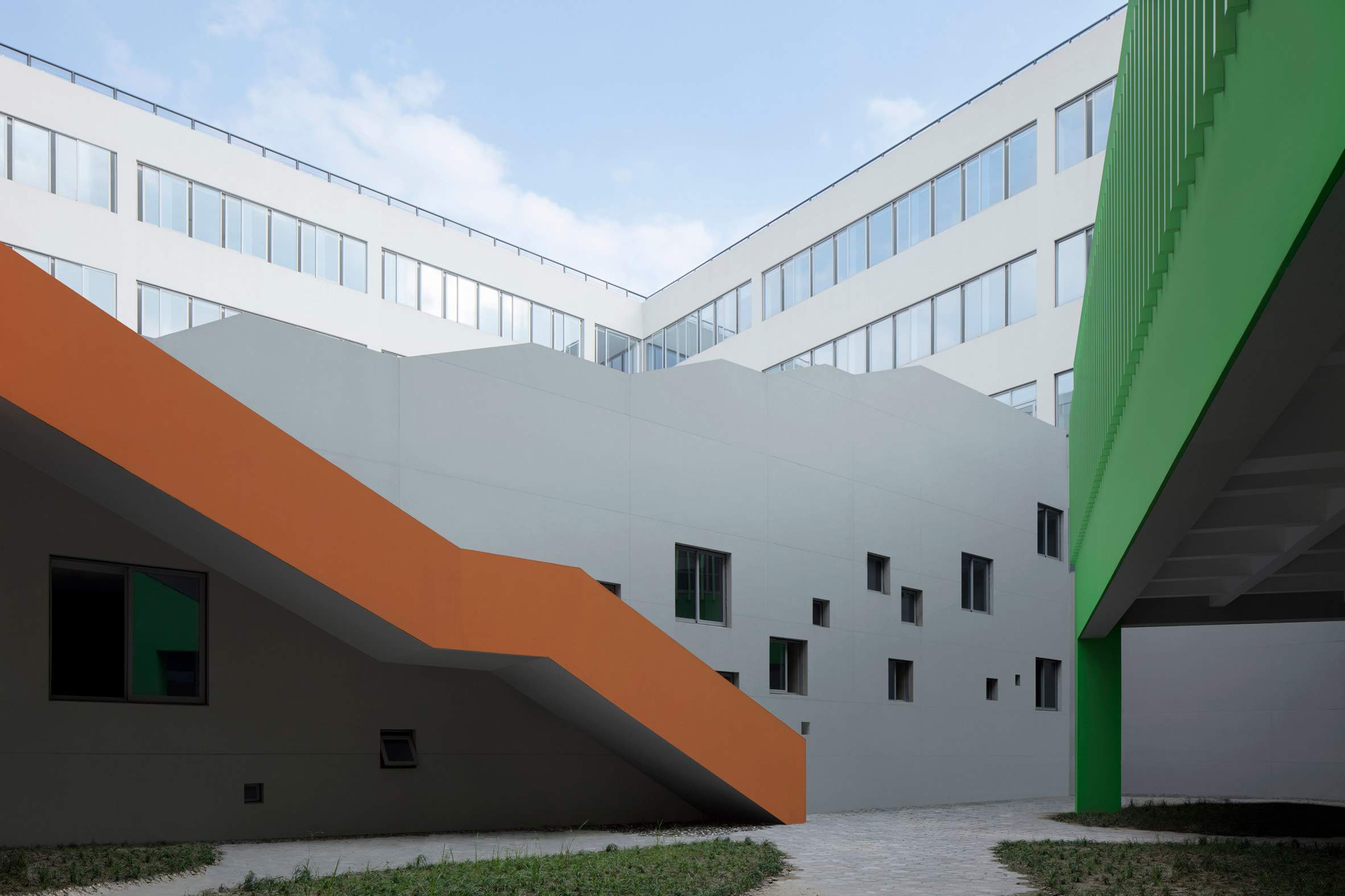 Orange staircase contrasts against a green library