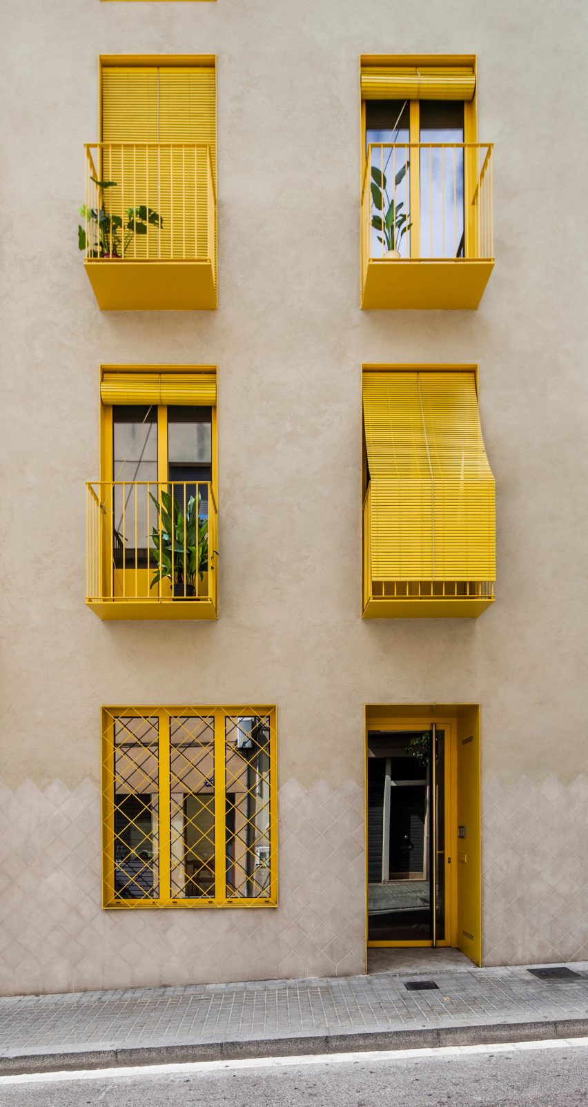 Yellow features contrast with the stucco by Anna & Eugeni Bach