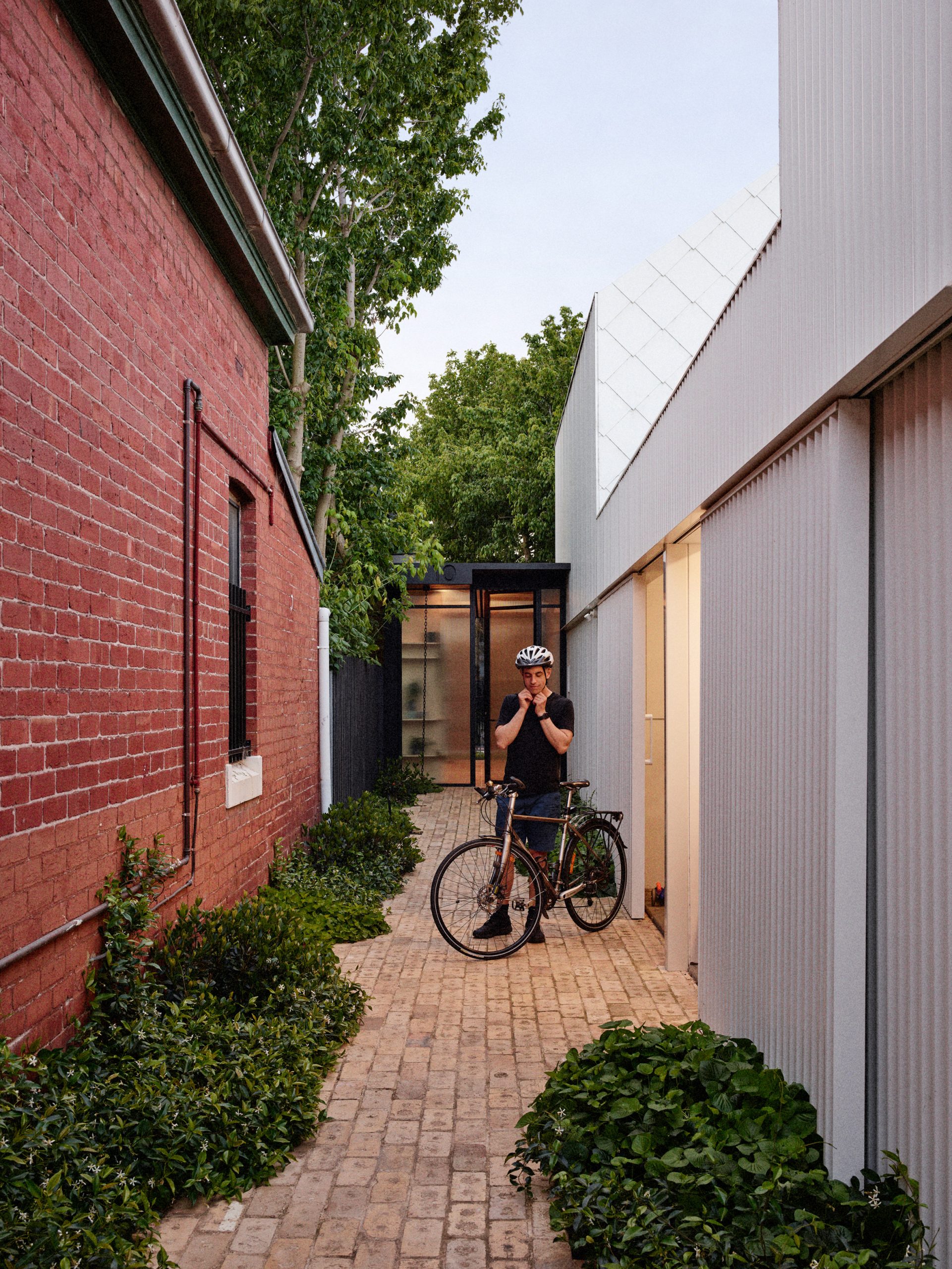 Brick passageway beside the garage and neighbouring home by Austin Maynard Architects