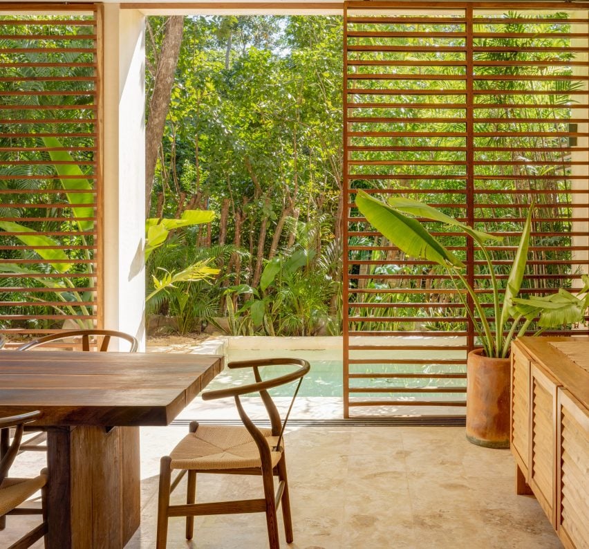 Wooden louvres and swimming pool of BAI-HA holiday complex in Tulum