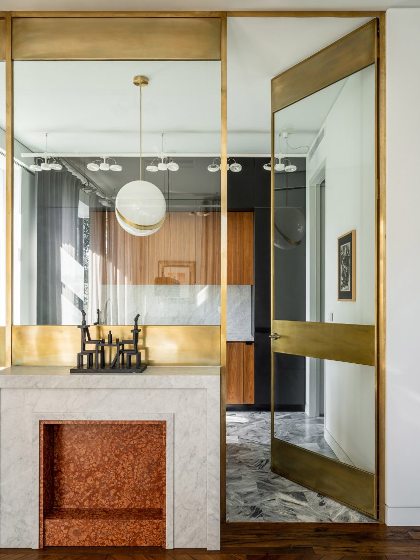 Brass-framed glass partition wall with marble mantlepiece in Moskow apartment
