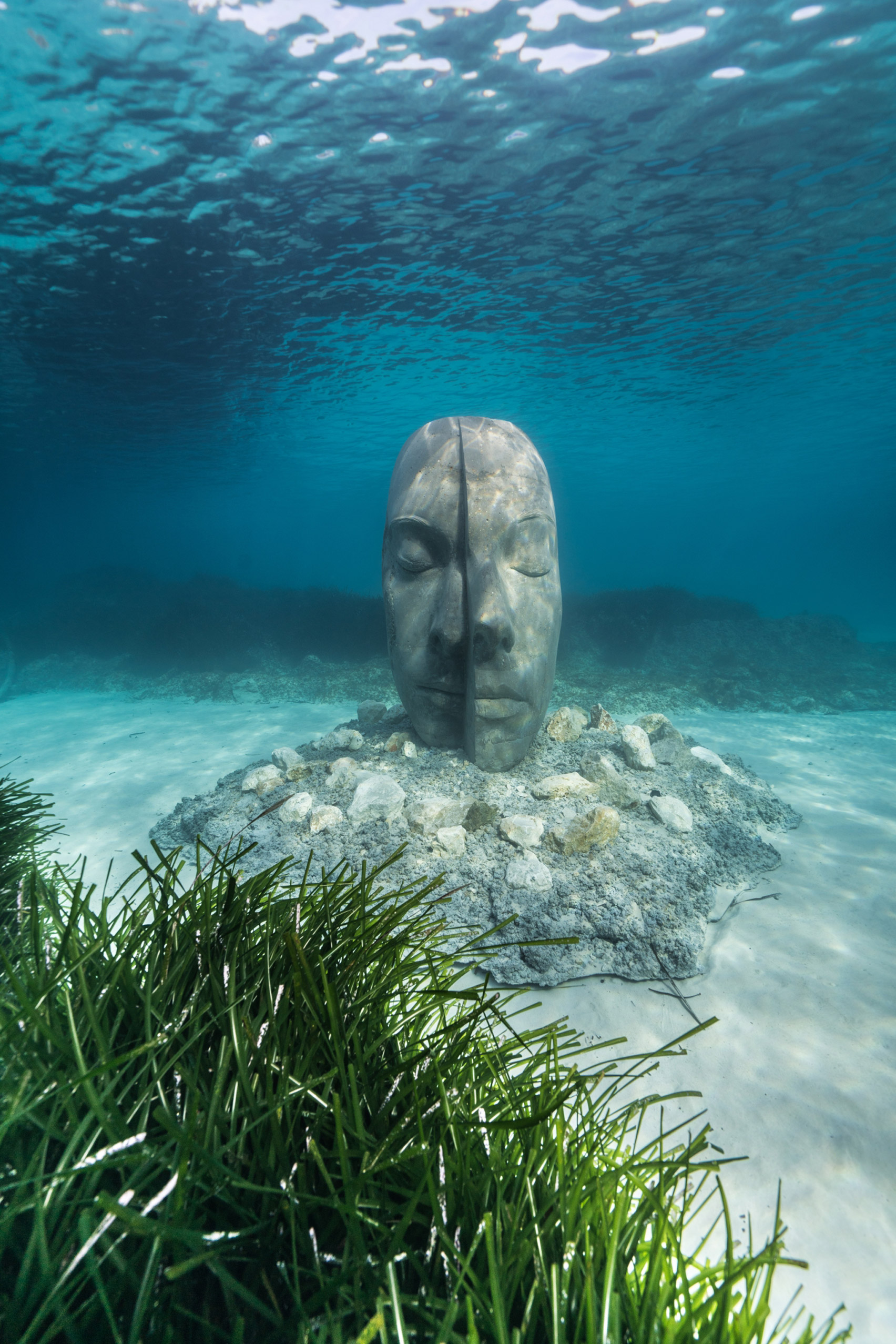 A sculpture of a human head submerged under water