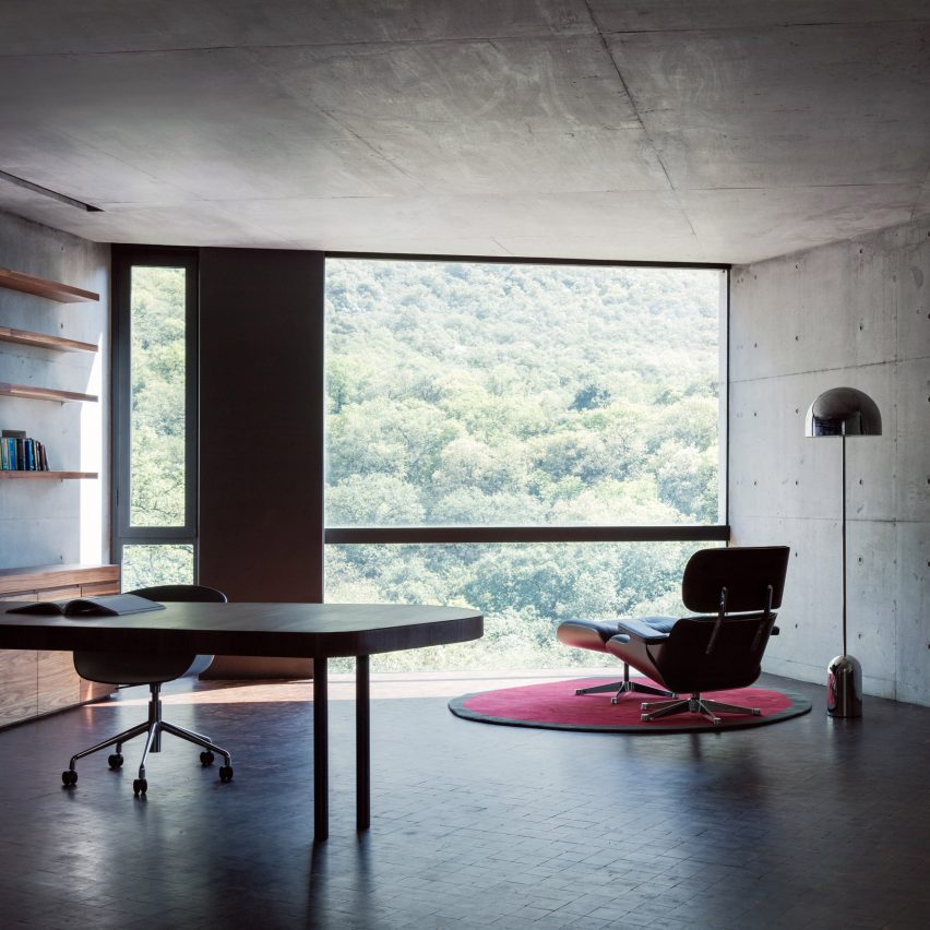 Home office with concrete walls and large window