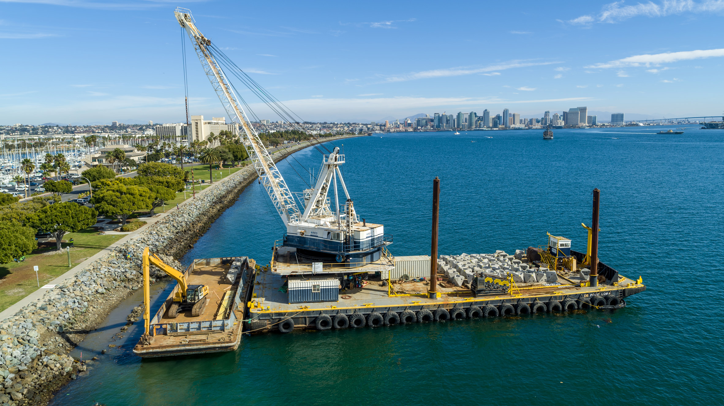 A barge in San Diego Bay carrying man-made rock pools