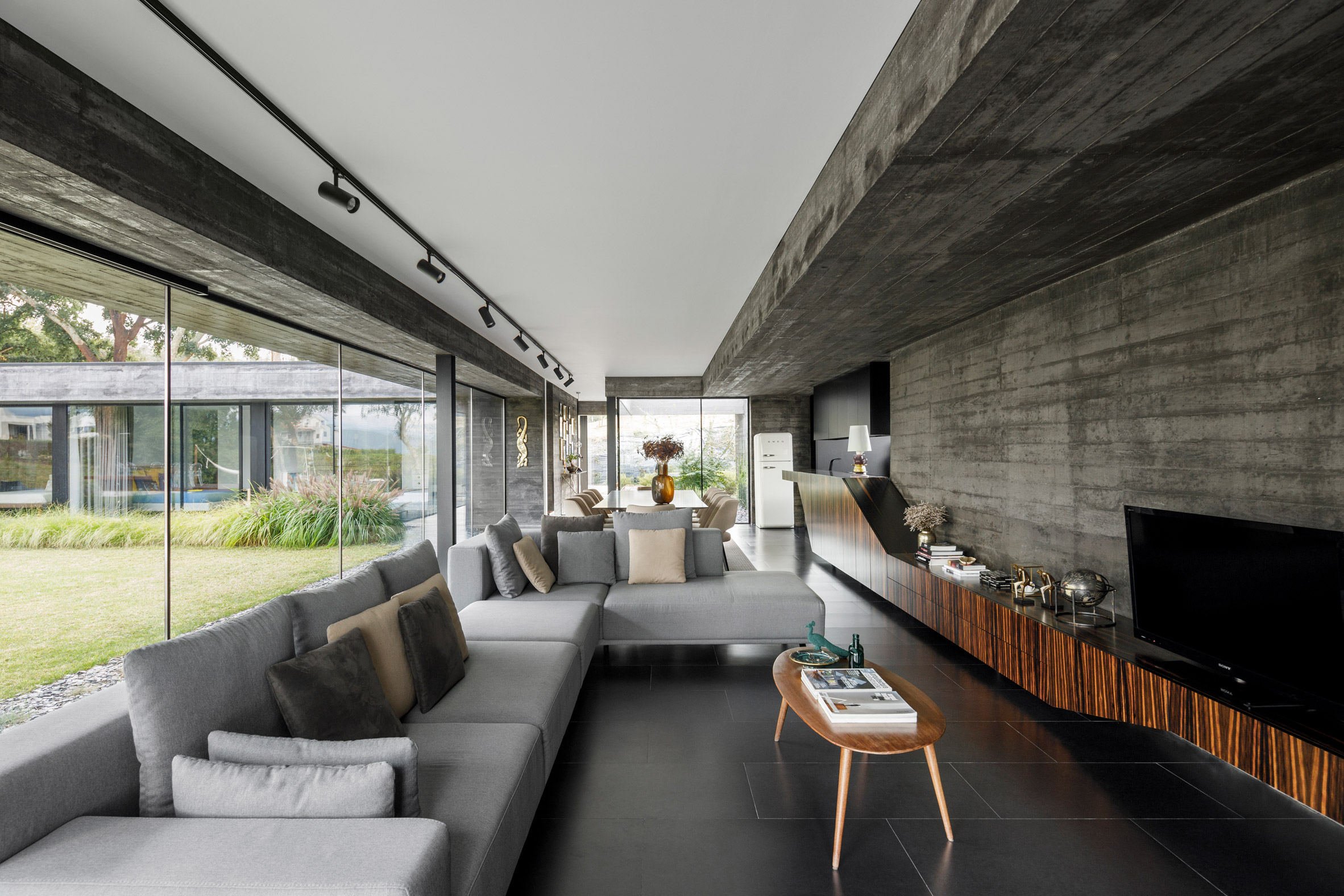 A concrete and glass-walled living room of Cork Oak House