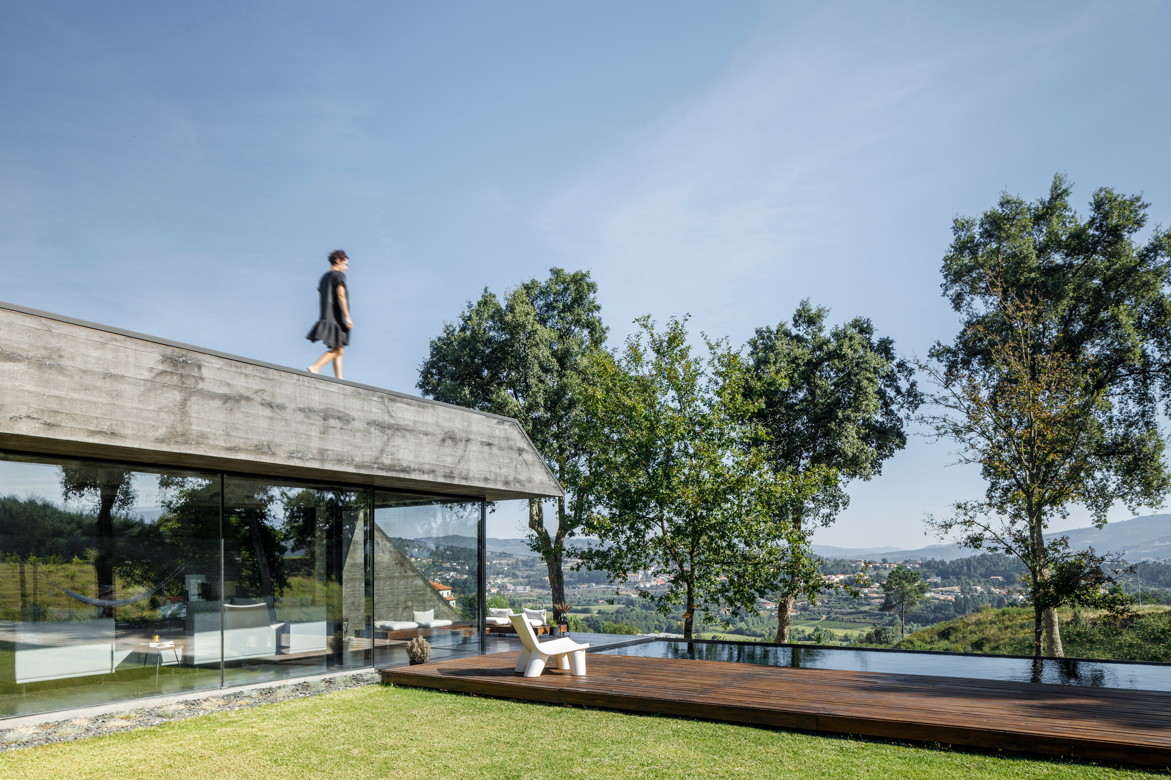 A hilltop concrete house with a roof terrace