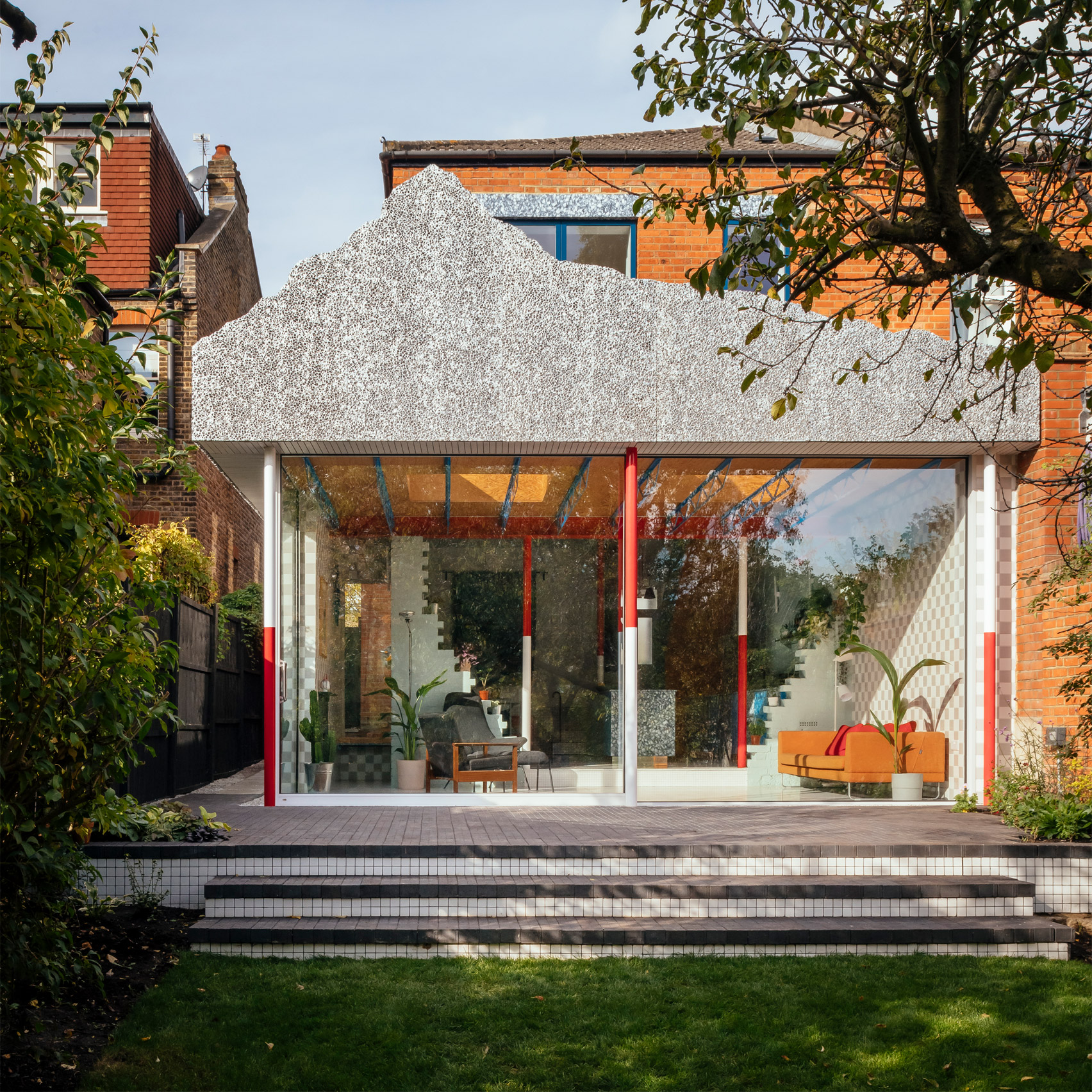 A colourful house extension with a grey mountain-like facade