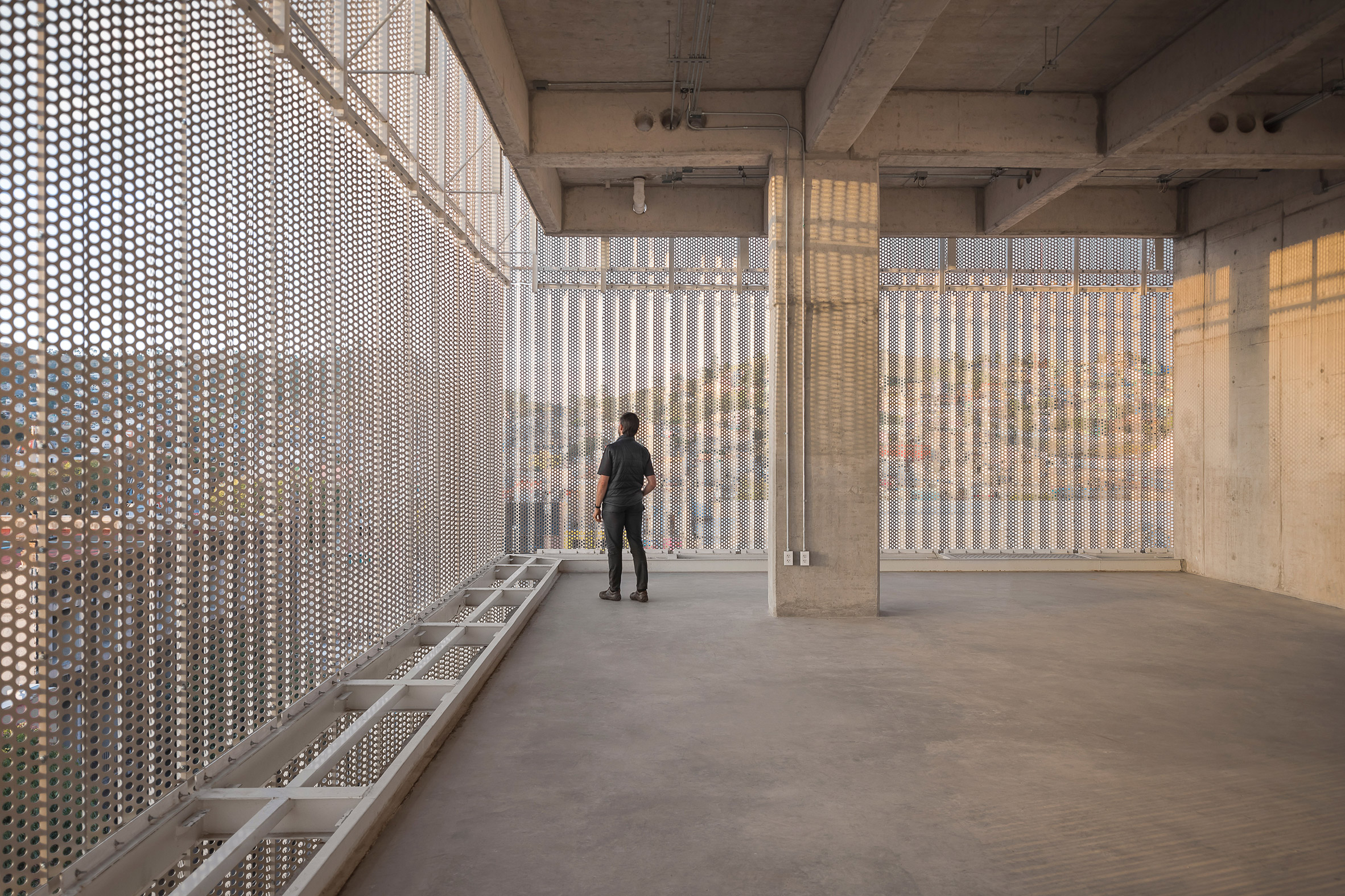 Concrete super structure and perforated metal facade