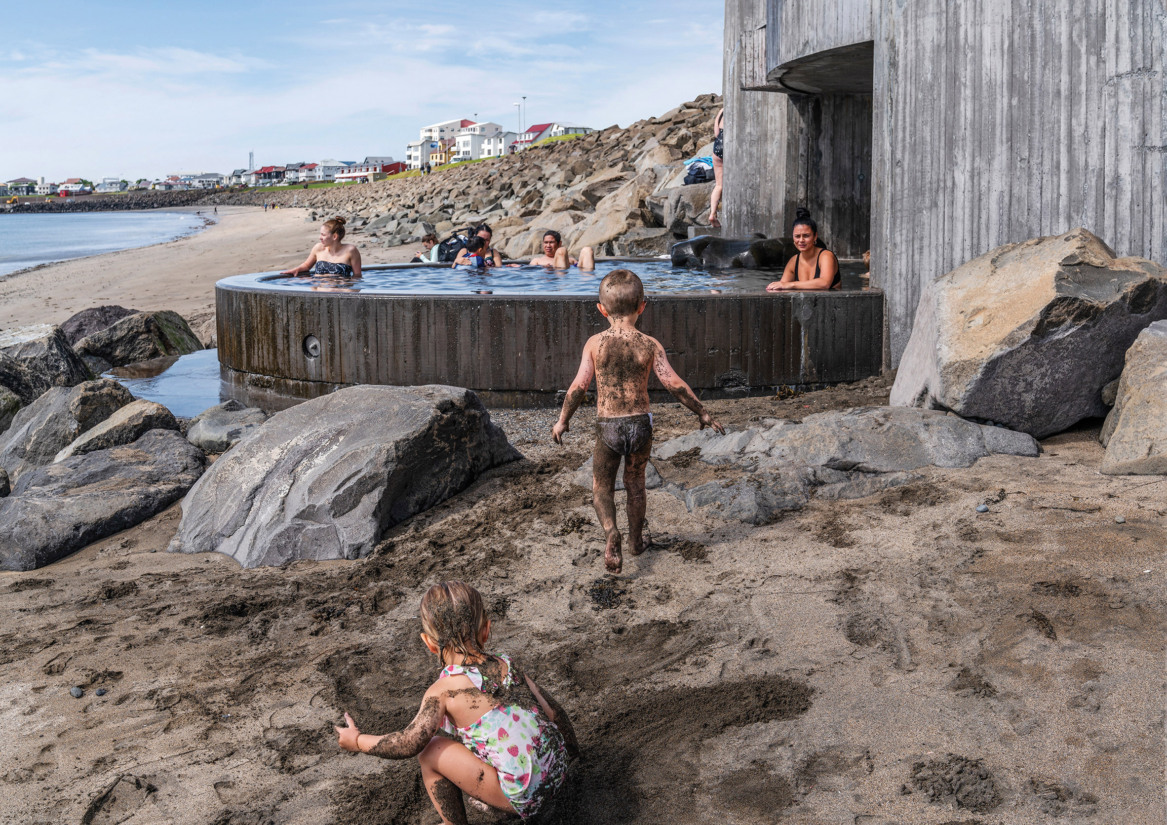Children playing at Guðlaug Baths by Basalt Architects