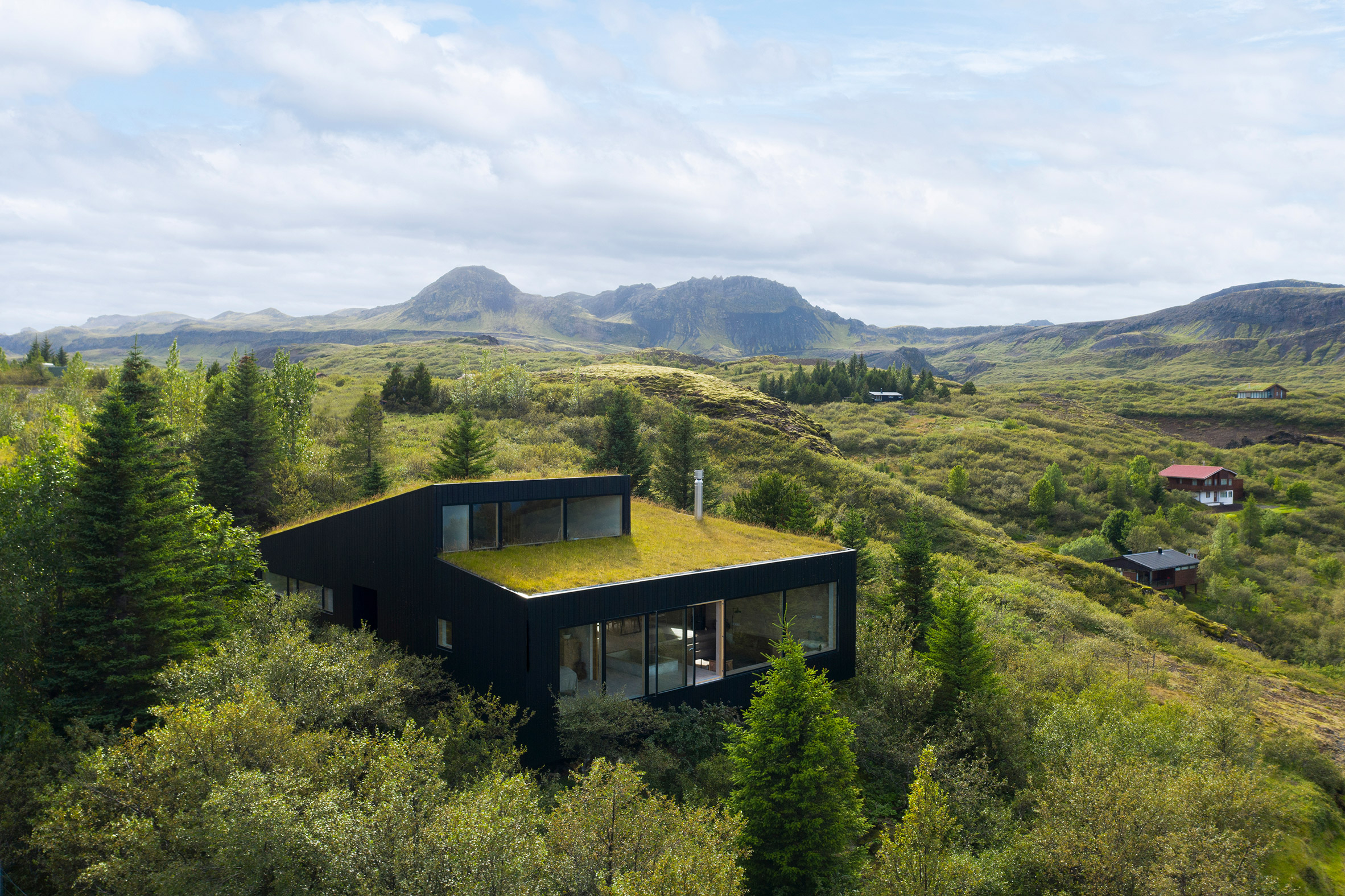 A black house with a green roof in rural Iceland