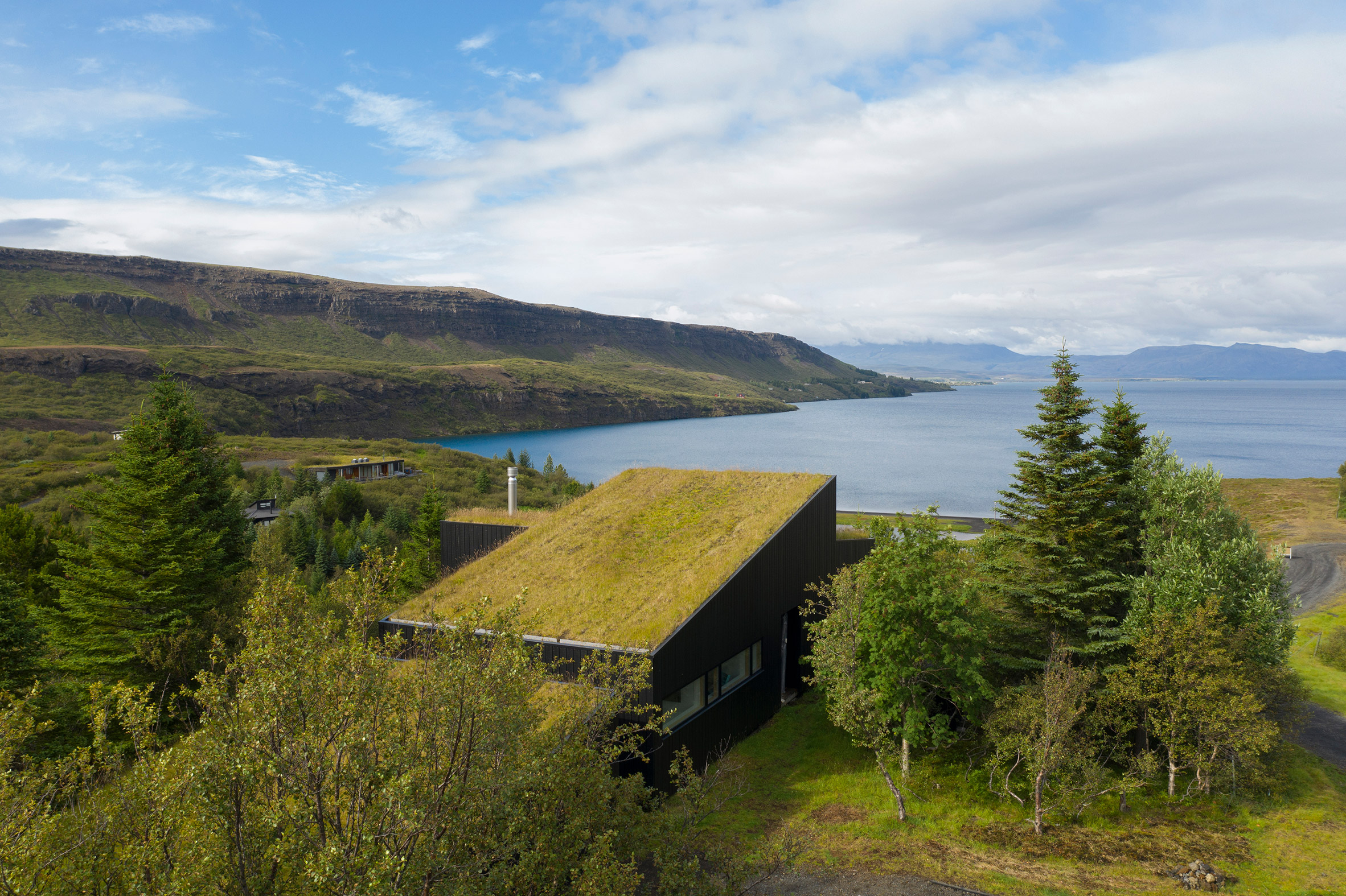 A house with a sloped green roof overlooking Lake Thingvallavatn