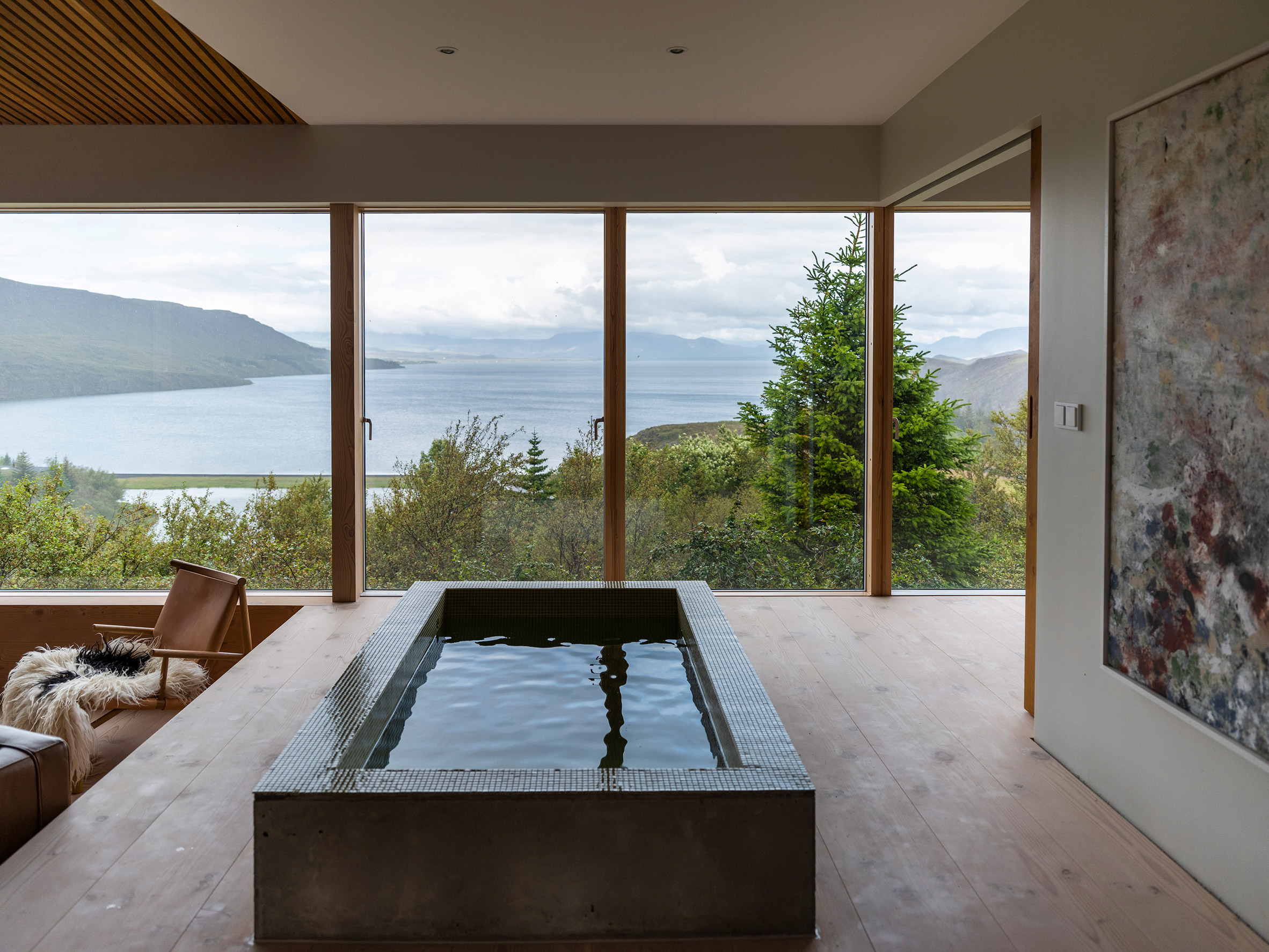 A pared-back lounge with a bathtub overlooking Lake Thingvallavatn