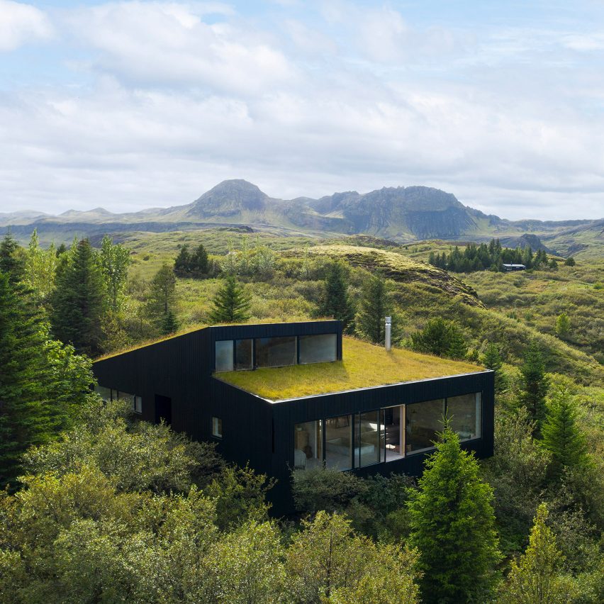 A black house with a green roof in rural Iceland