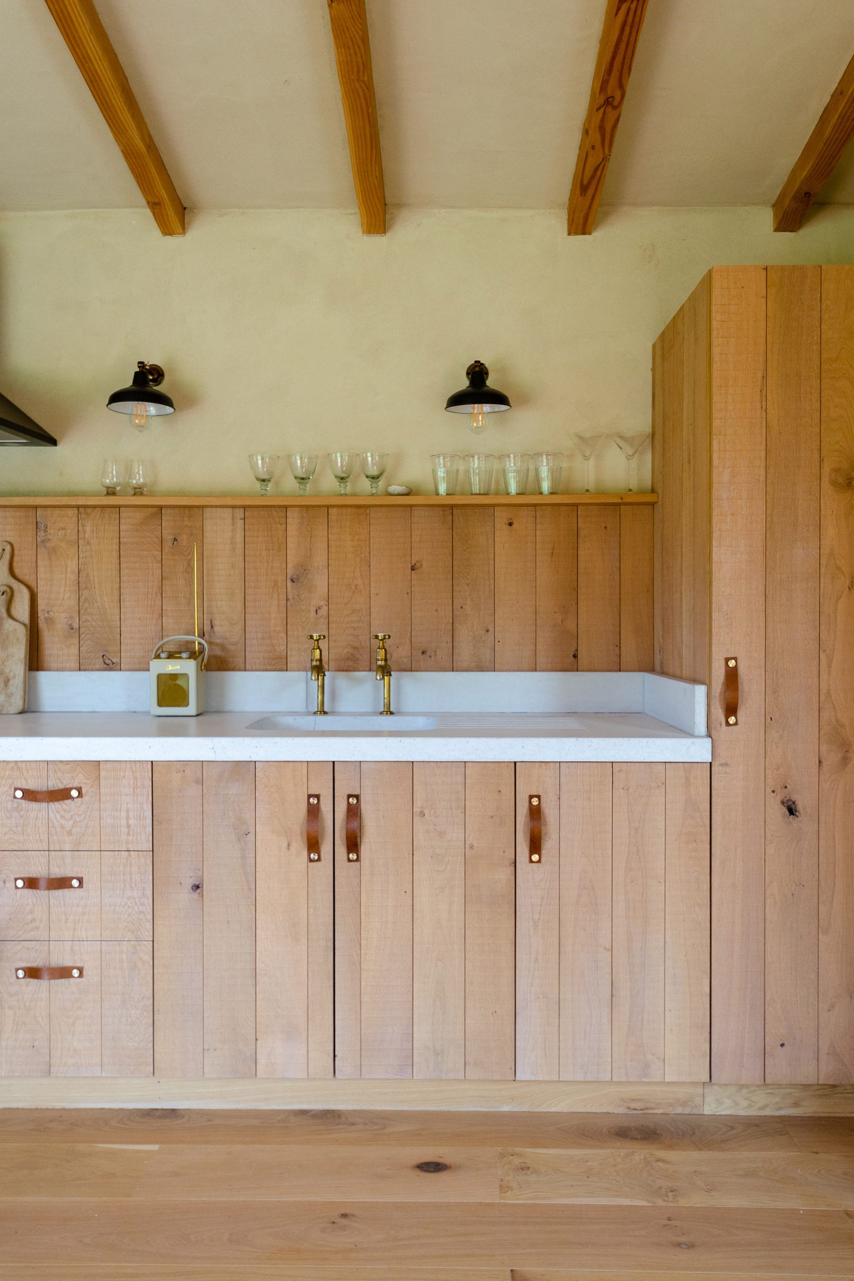 A cabin's wooden kitchen with leather handles
