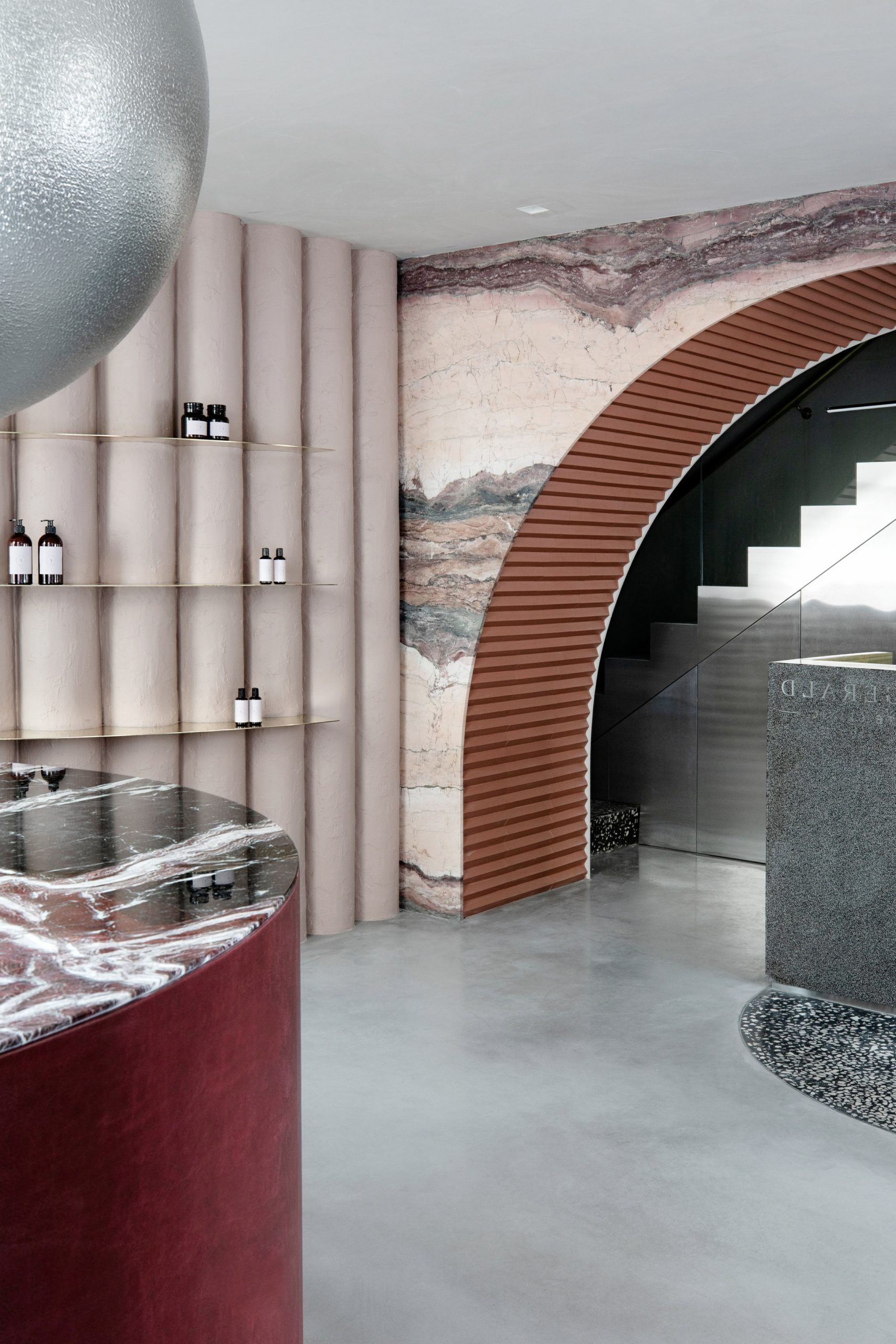 Marble accents and undulating plaster wall in skincare clinic