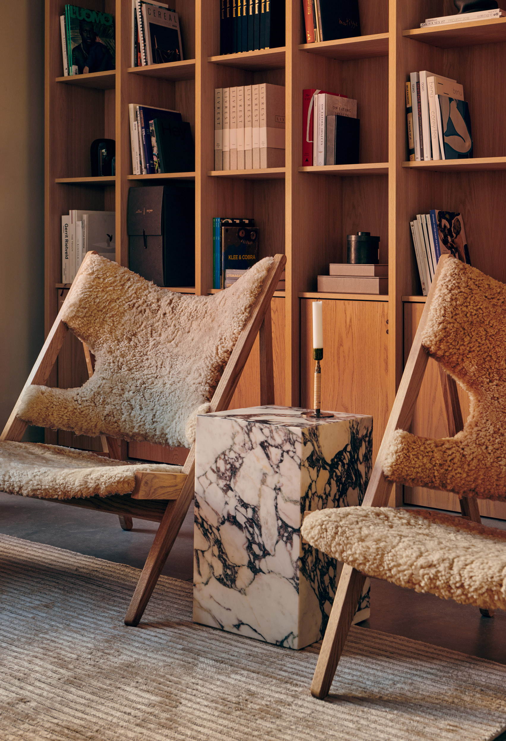 A pair of oak lounge chairs with sheepskin upholstery