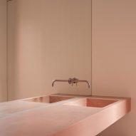 A bathroom with a pink concrete sink