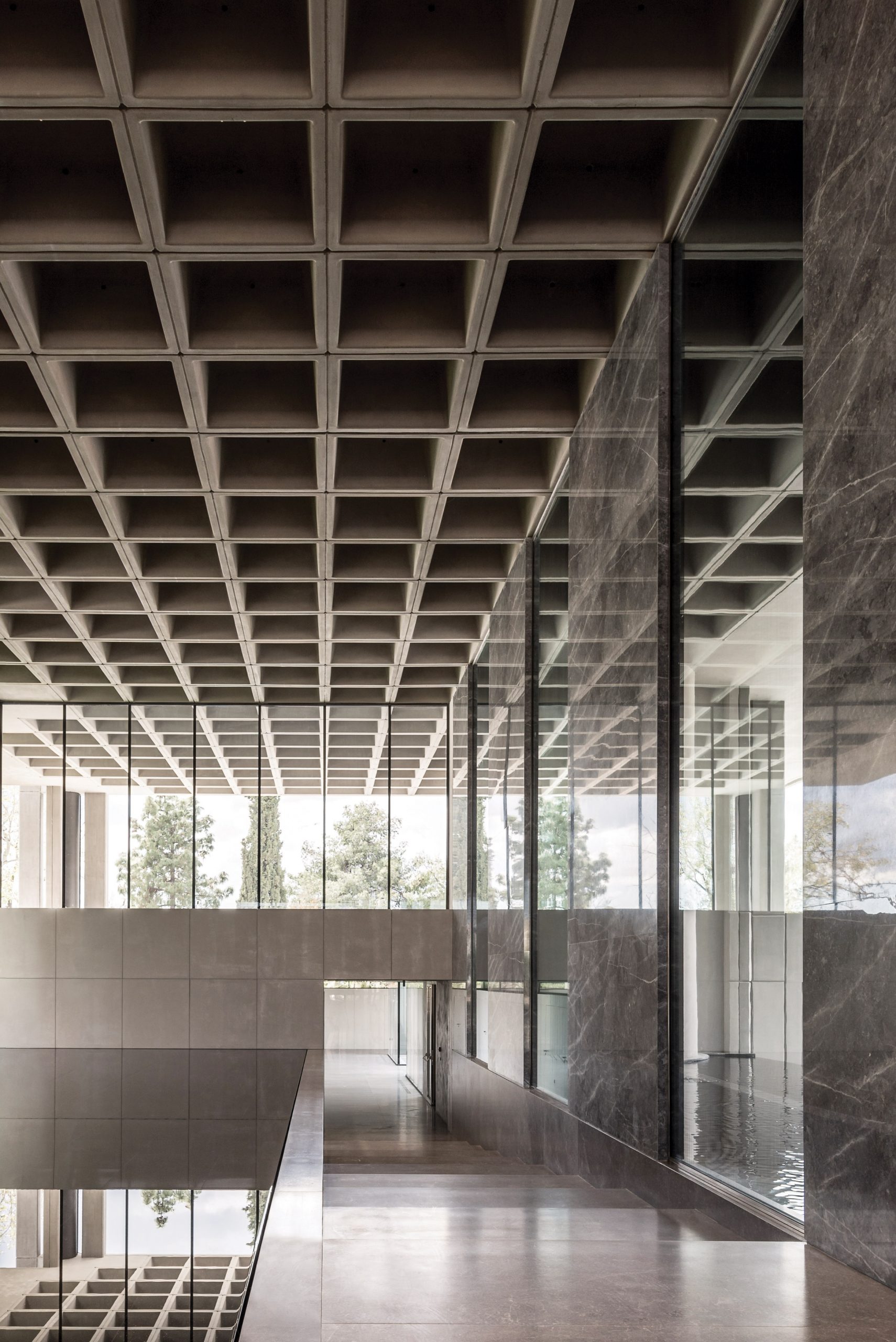A brutalist office entrance with a waffle slab ceiling