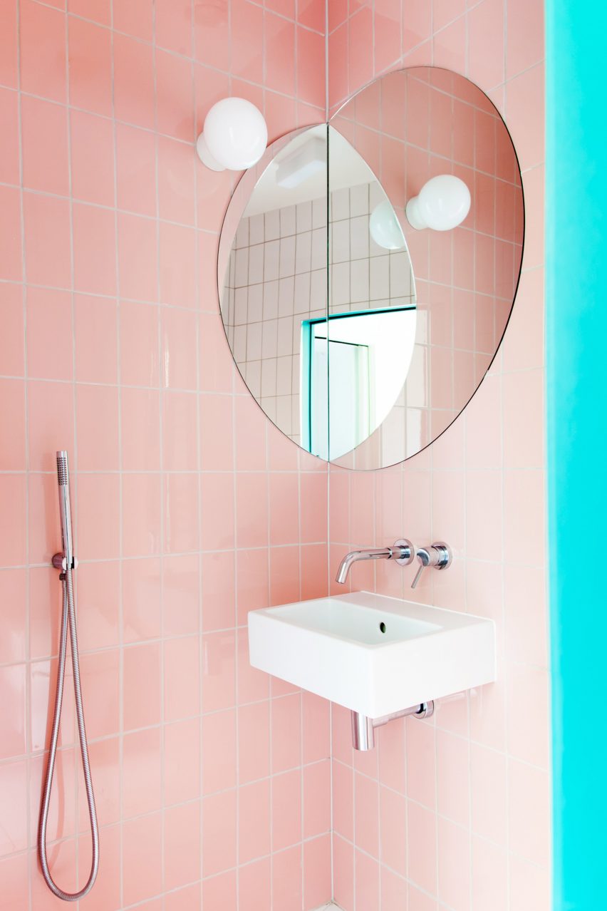 A bathroom with pink wall tiles