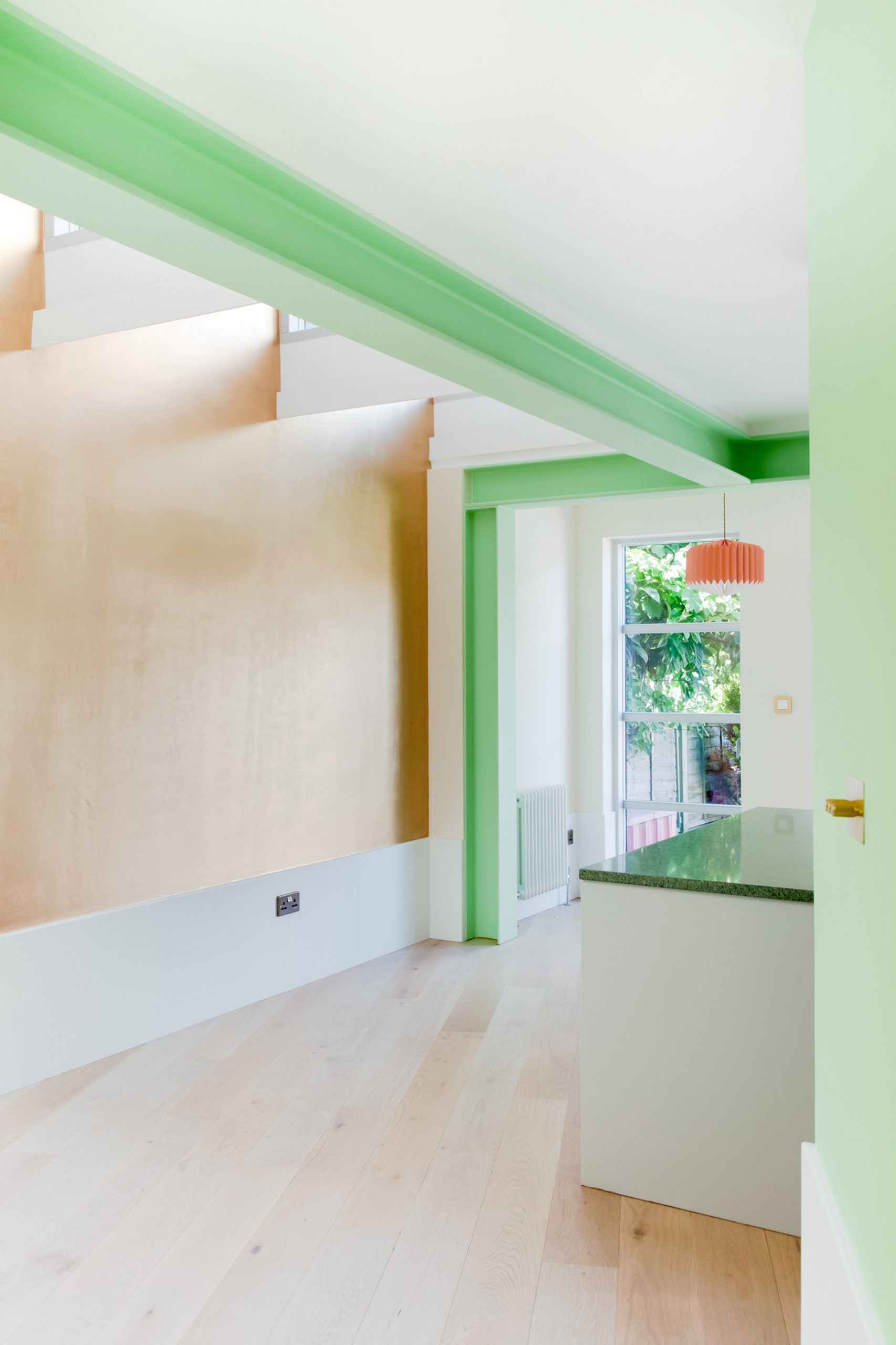 A light kitchen extension with green structural beams
