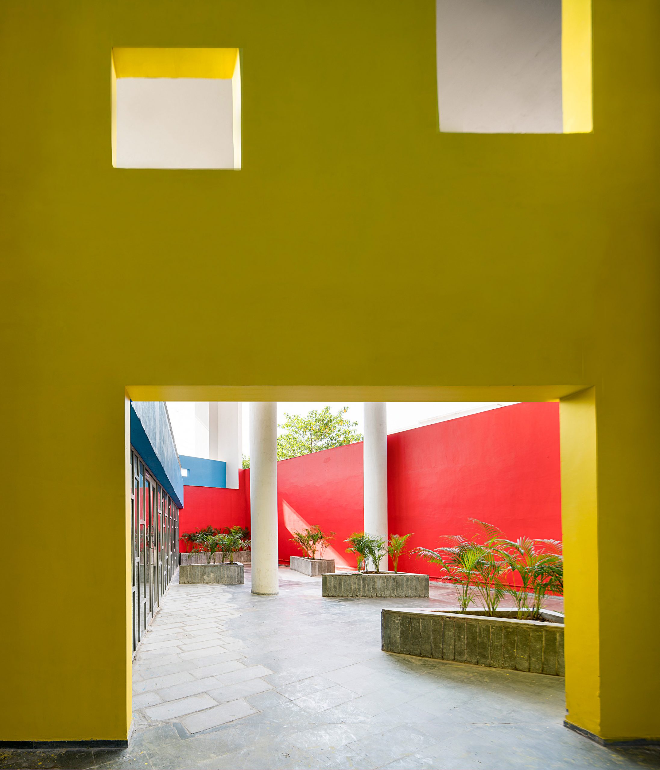 A courtyard lined with walls painted in primary colours