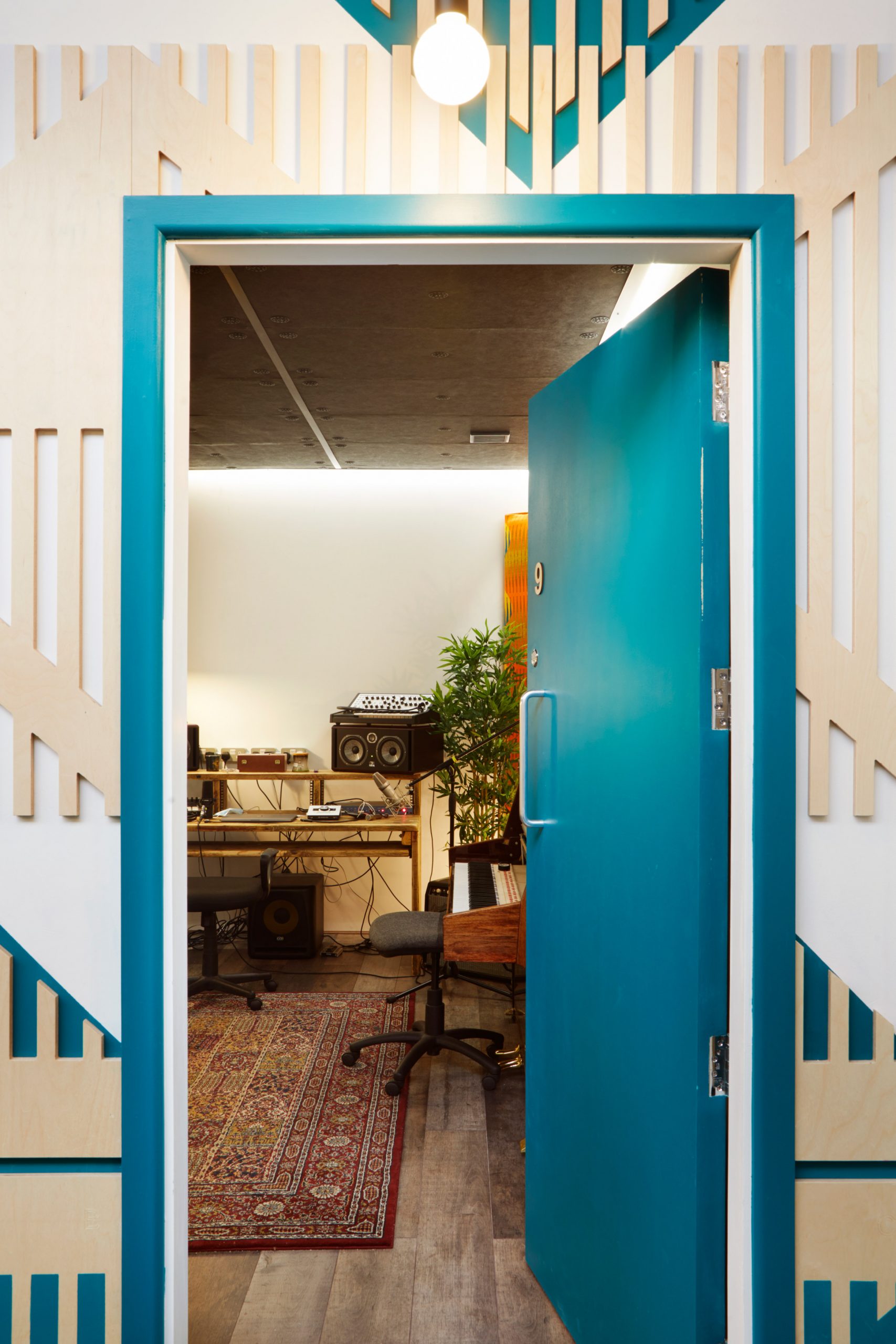 A teal-hued door leading into a London music studio