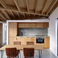 A wooden kitchen with an exposed roof