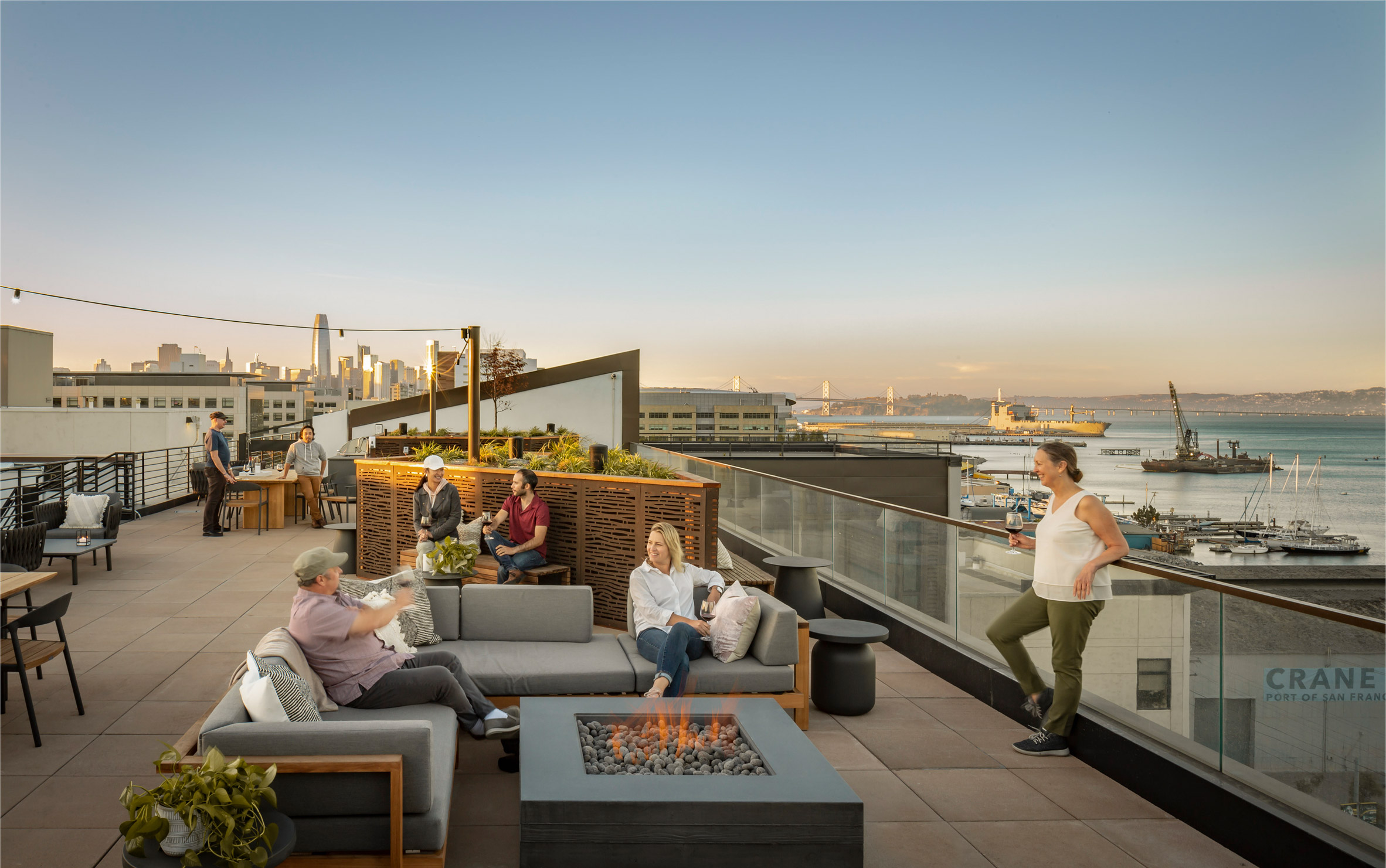 Rooftop terrace with fire pits by Woods Bagot