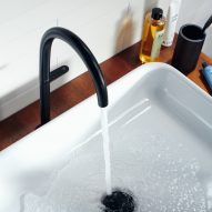A white sink with a black tap