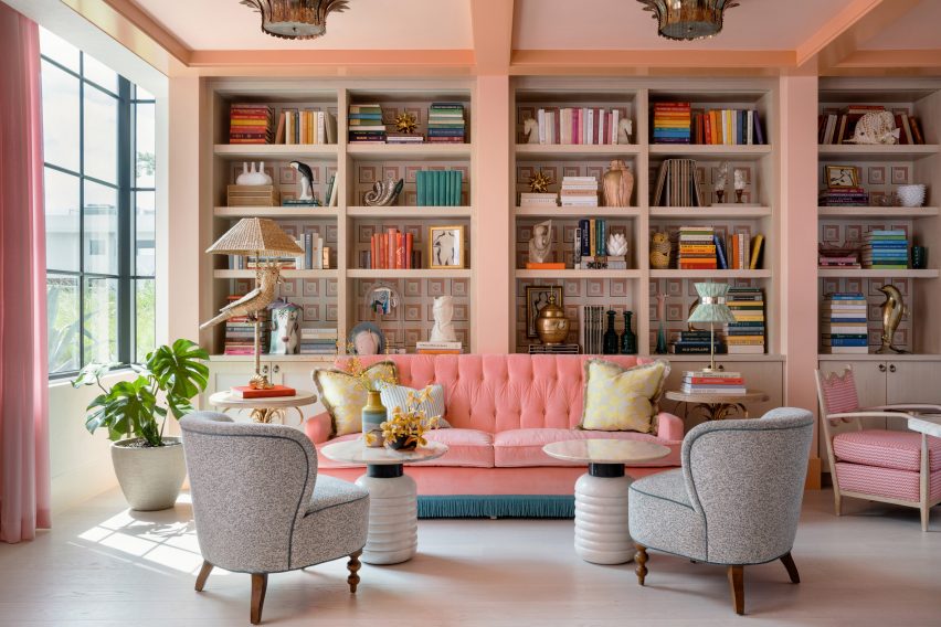Library of the Goodtime Hotel with pink couch and built-in bookshelves