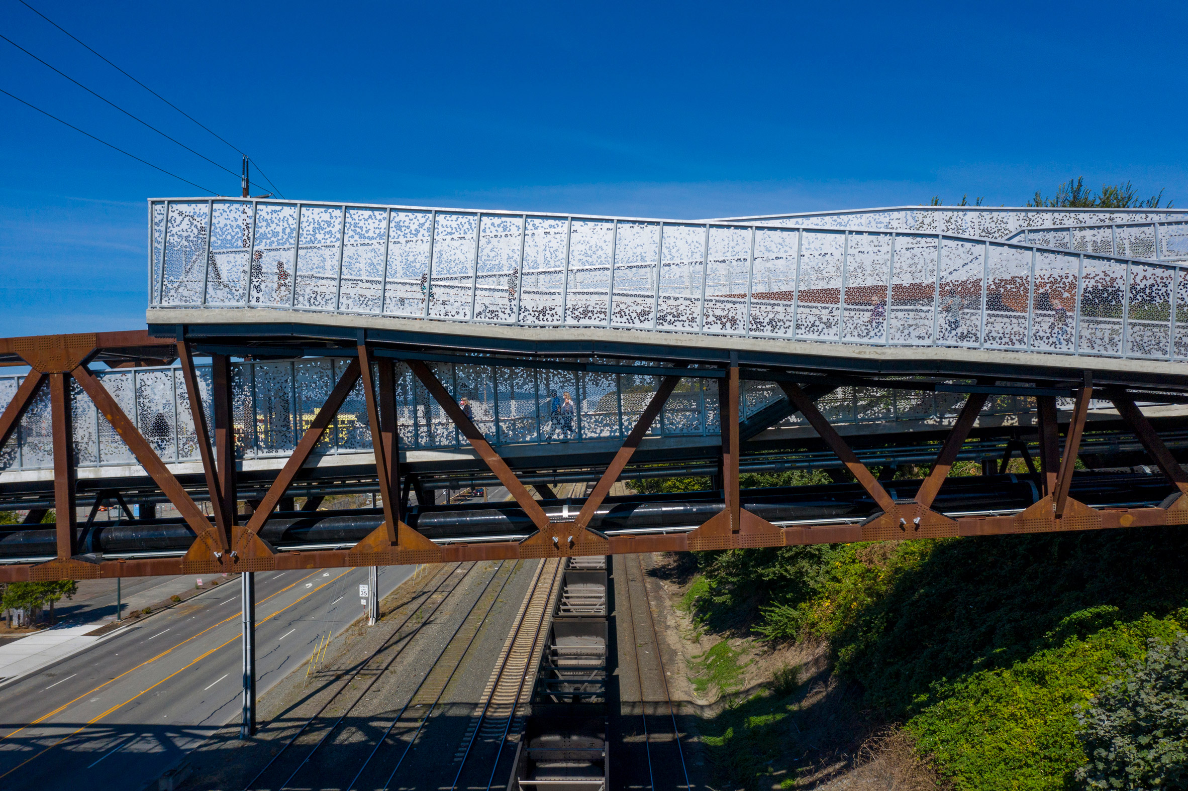 Weathering steel trusses and perforated steel guardrails of a bridge