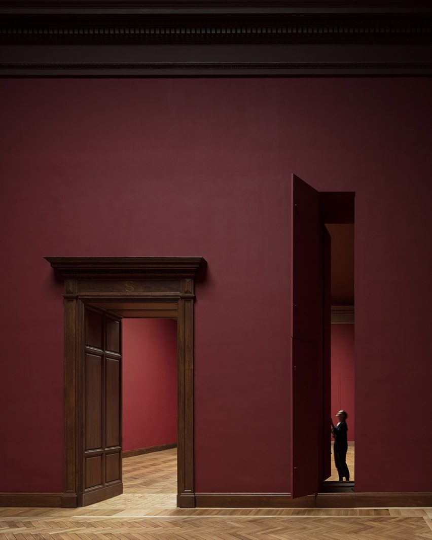 Maroon walls and vertical hatches for moving paintings in Royal Museum of Fine Arts Antwerp by Kaan Architecten