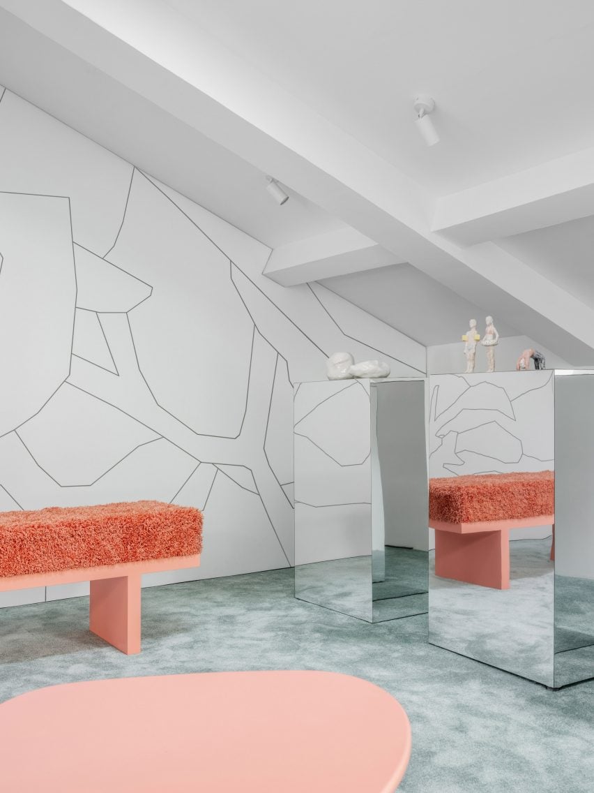 Coral-coloured table and bench with mirrored plinths and linework mural in Moscow store interior by Elena Lokastova
