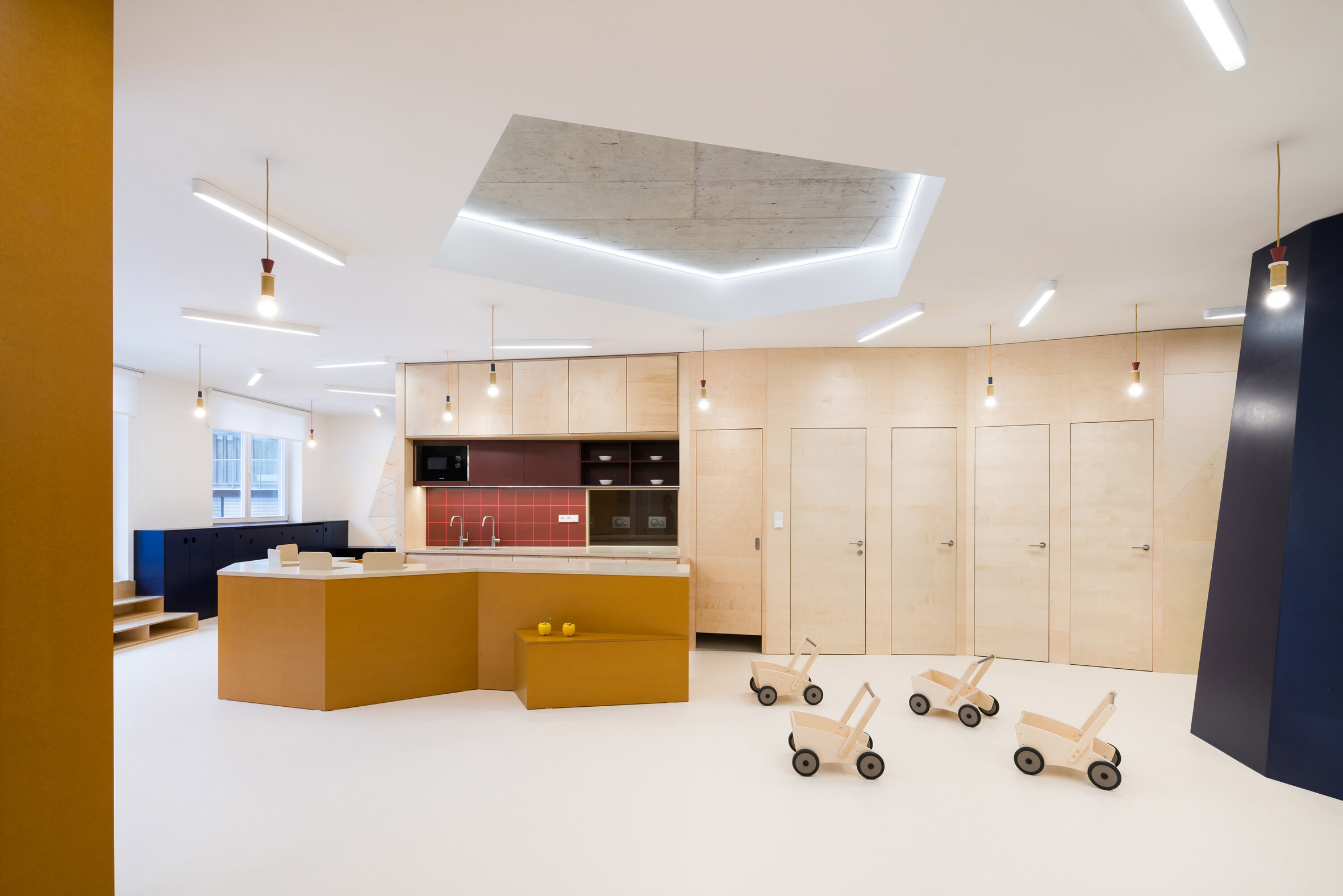 Kitchen area with plywood cladding in Prague kindergarten by No Architects